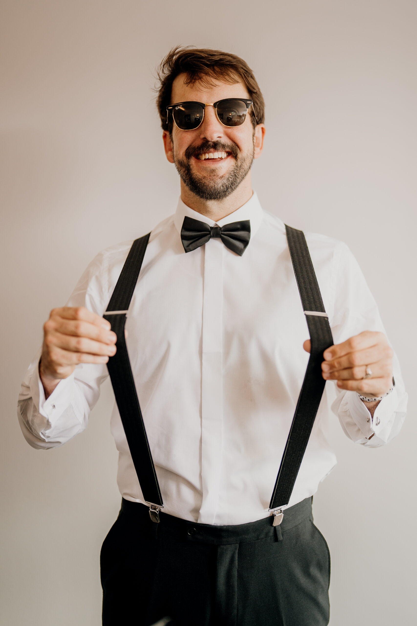 A man wearing sunglasses and a bow tie