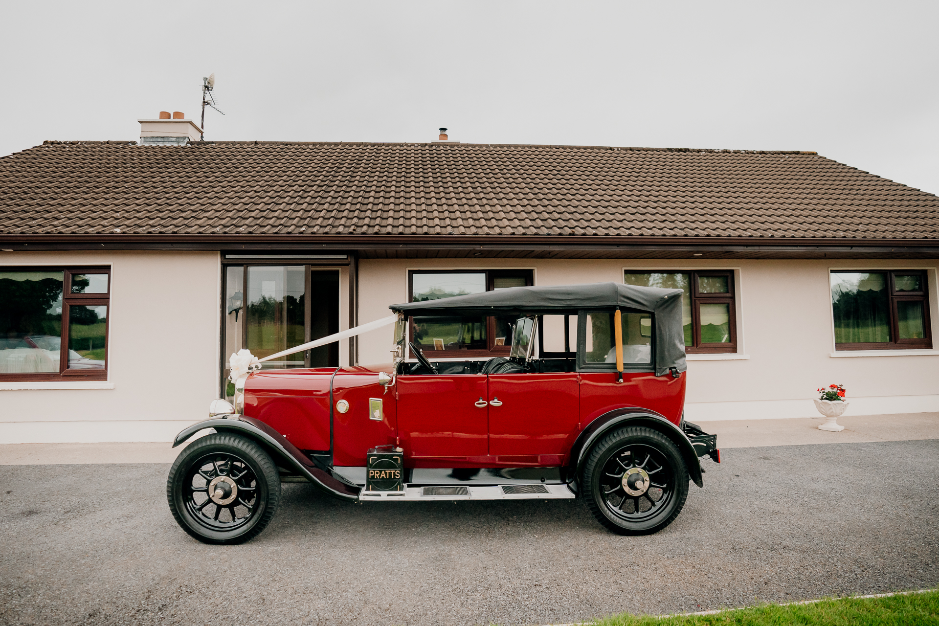 A red car parked in front of a house