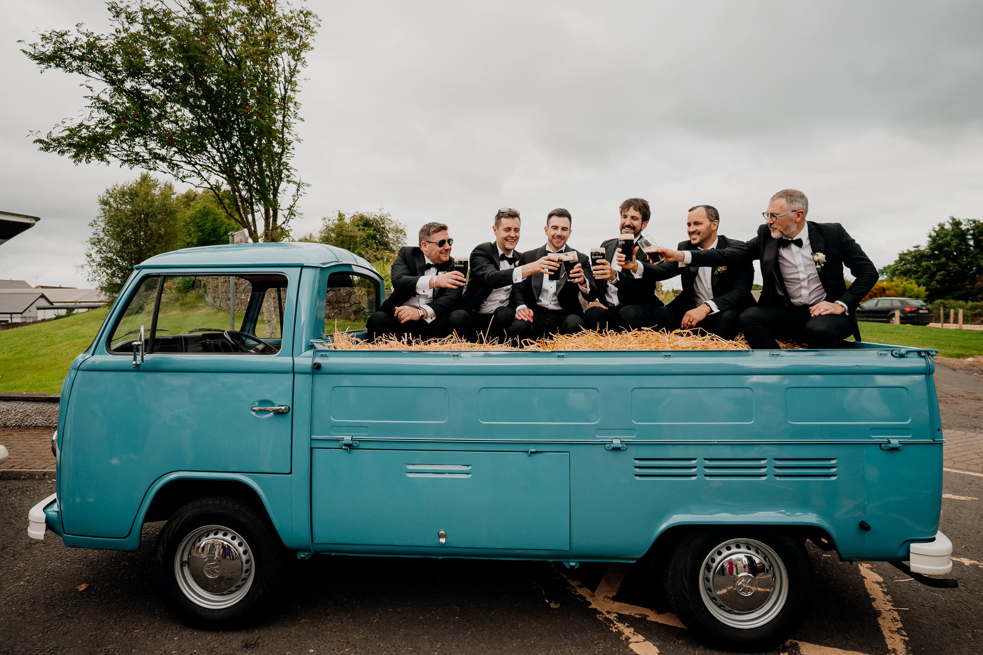 A group of men in suits sitting in a blue pickup truck