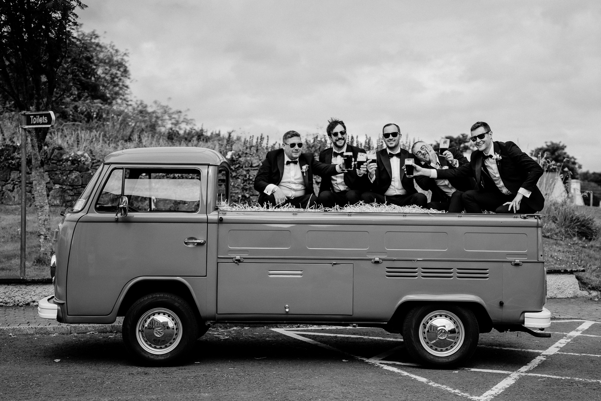 A group of people sit on top of a pickup truck