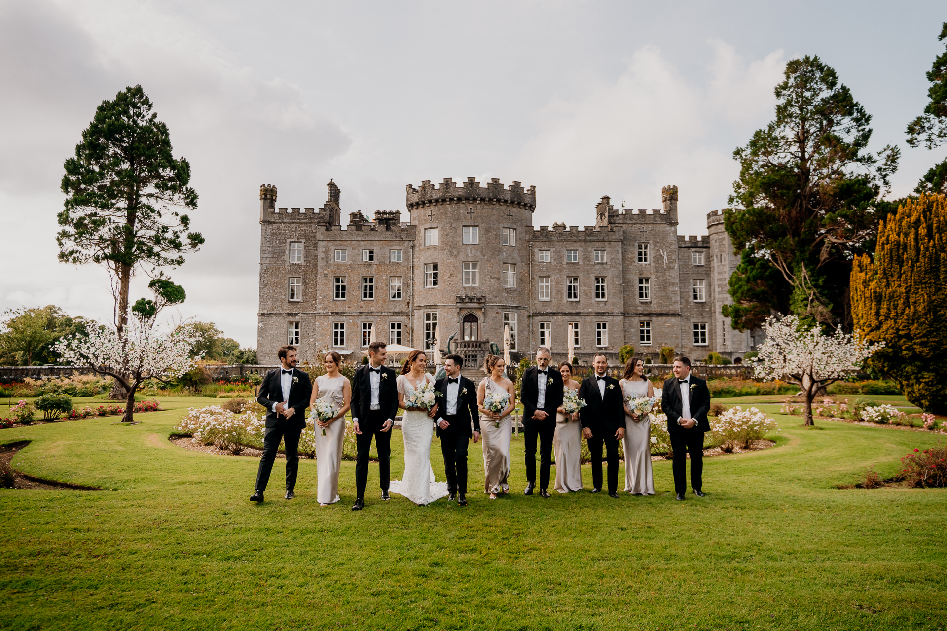 A group of people in formal wear standing in front of a large building