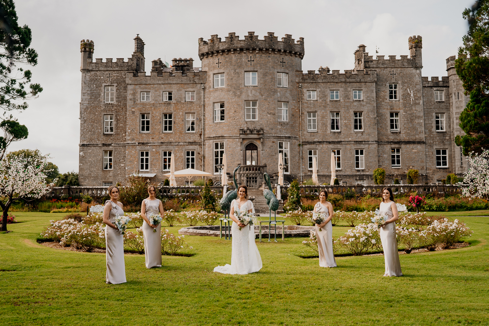 A group of people in white dresses standing in front of a large building