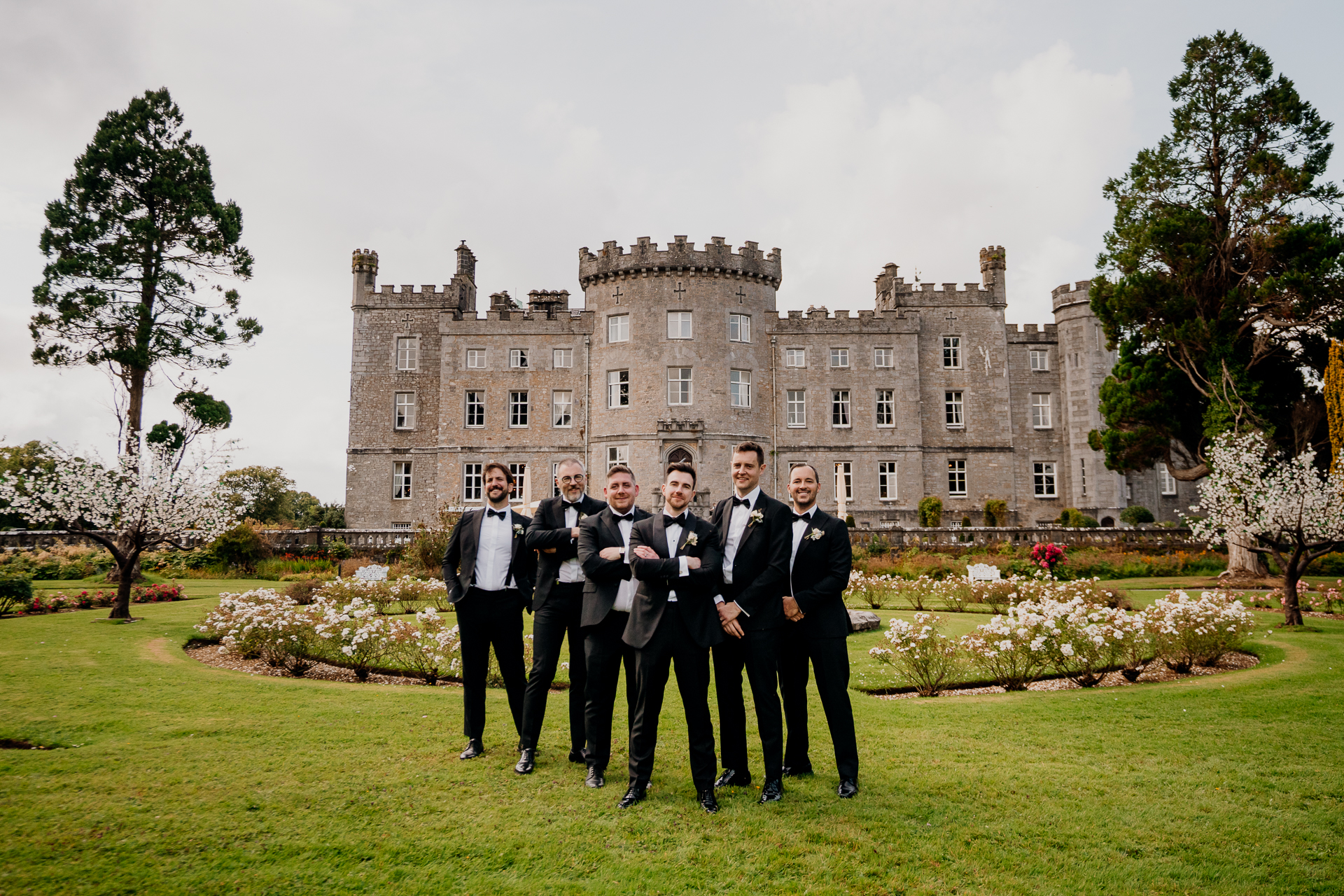 A group of men in suits standing in front of a large building