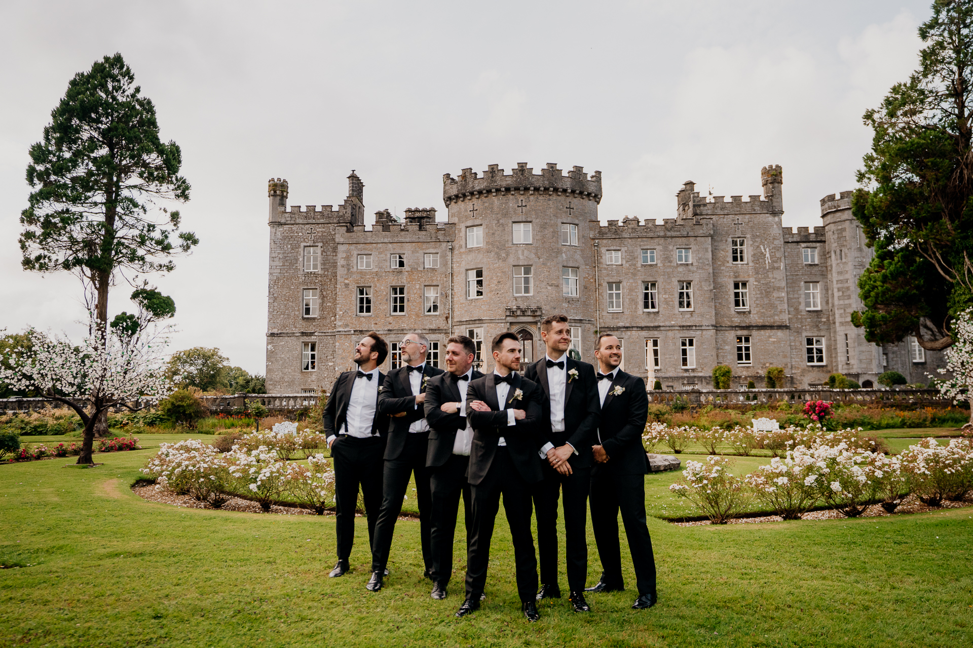 A group of men in suits standing in front of a large building