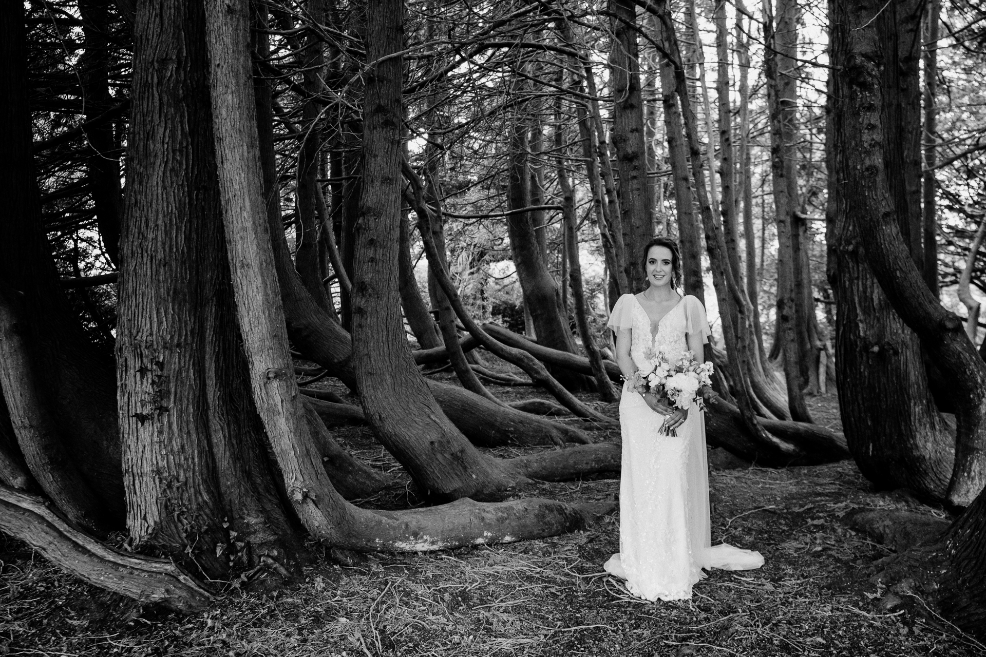 A person in a white dress standing in a forest