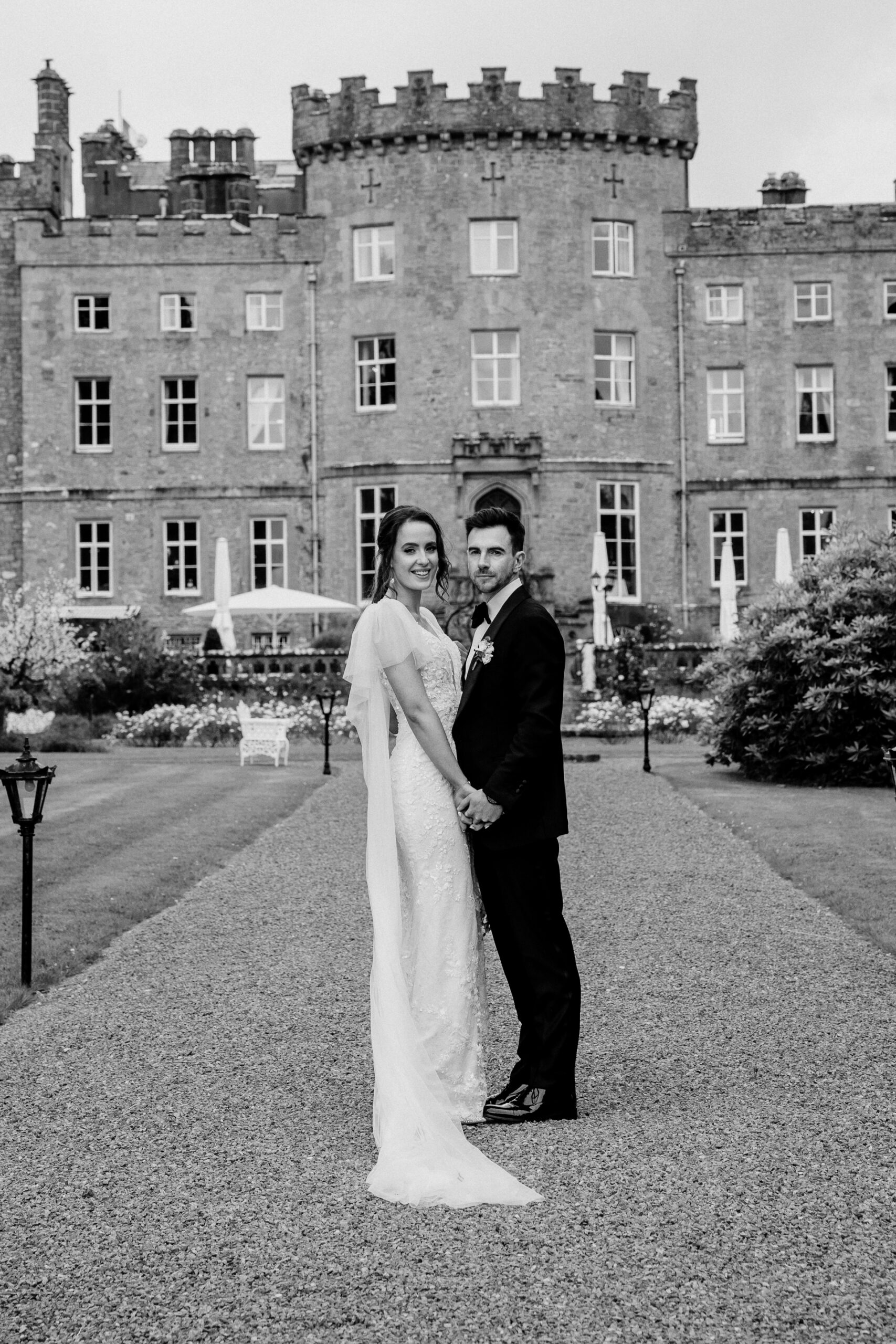 A man and woman posing in front of a large building