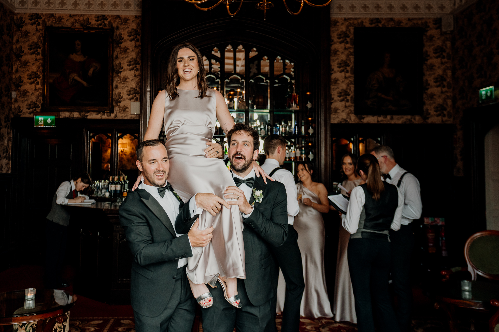 A man and woman posing for a picture with a man in a tuxedo