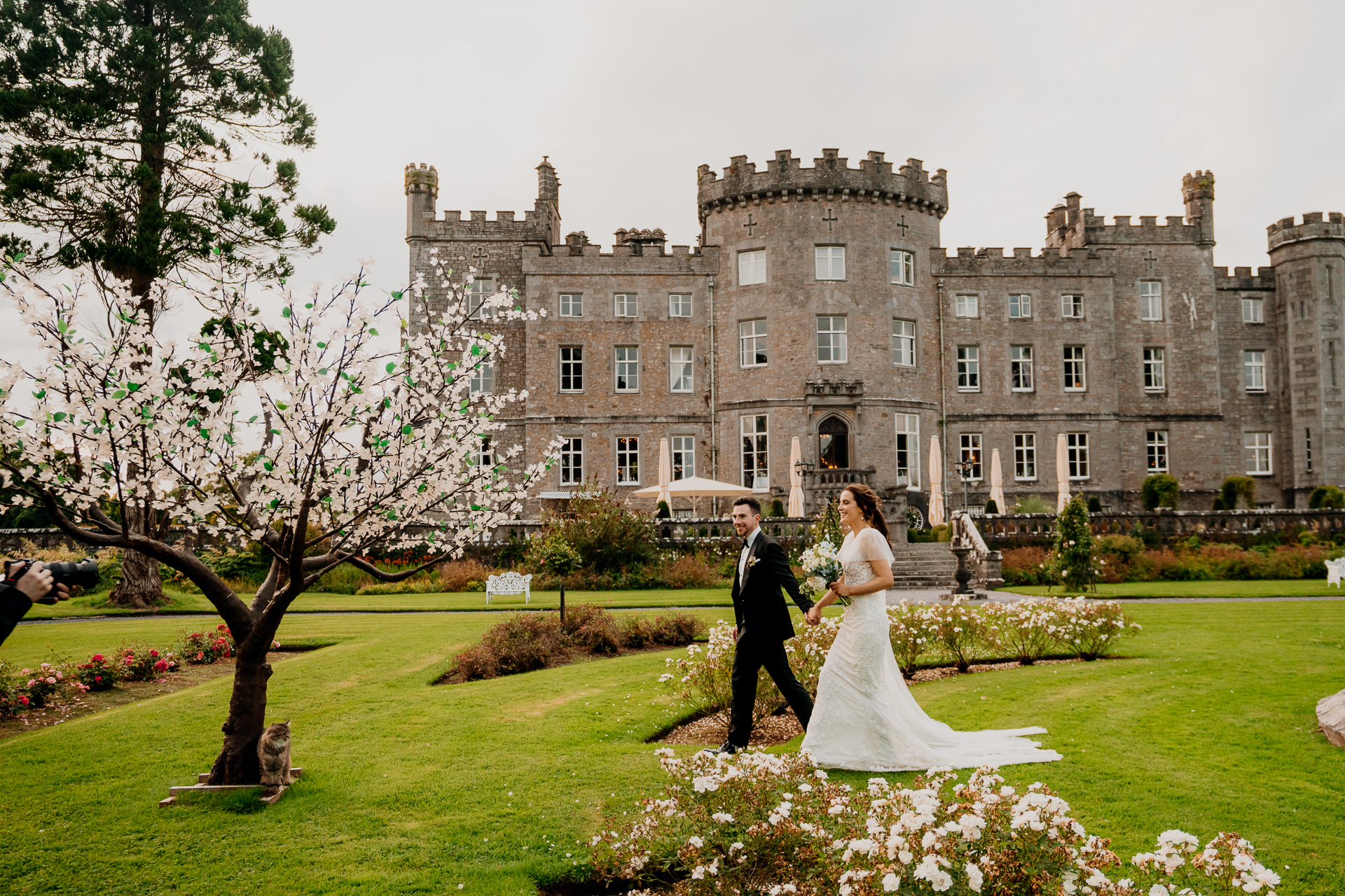 A man and woman in wedding attire in front of a large building