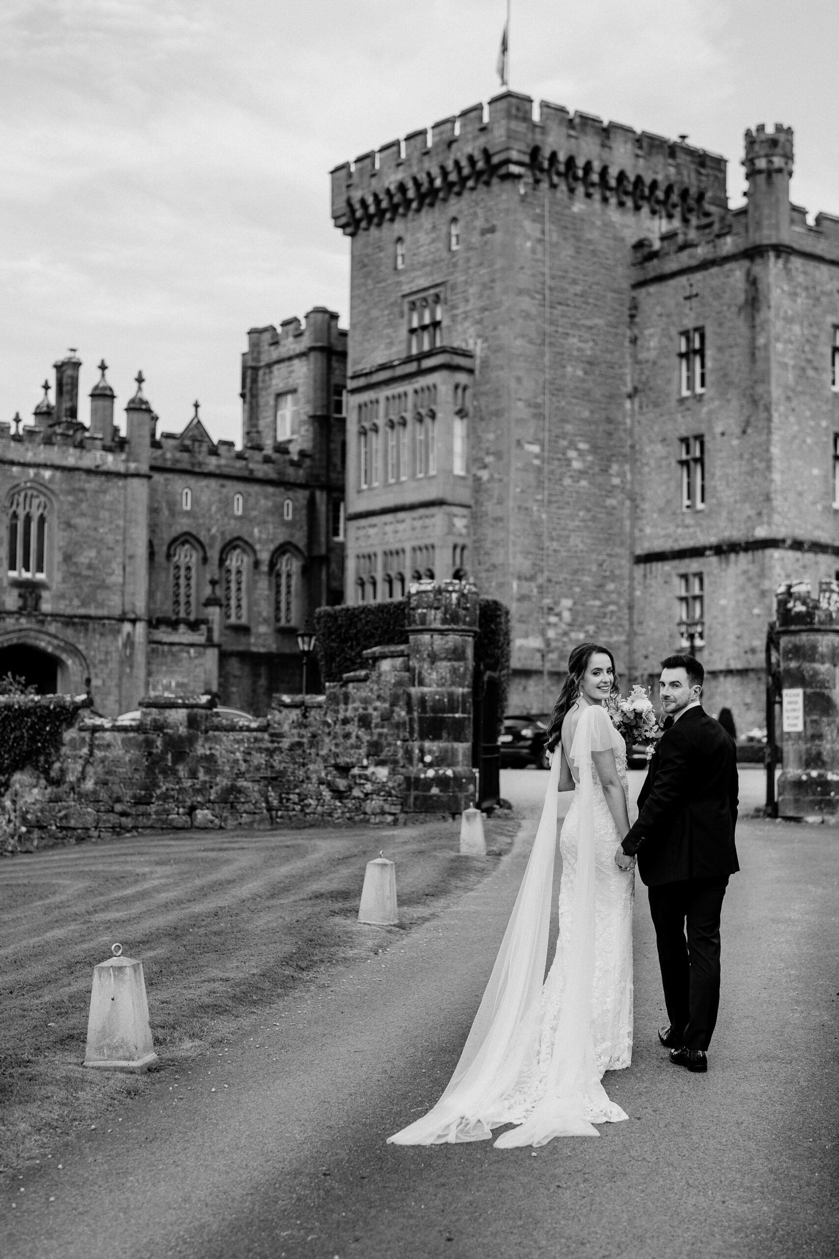 A bride and groom in front of a castle