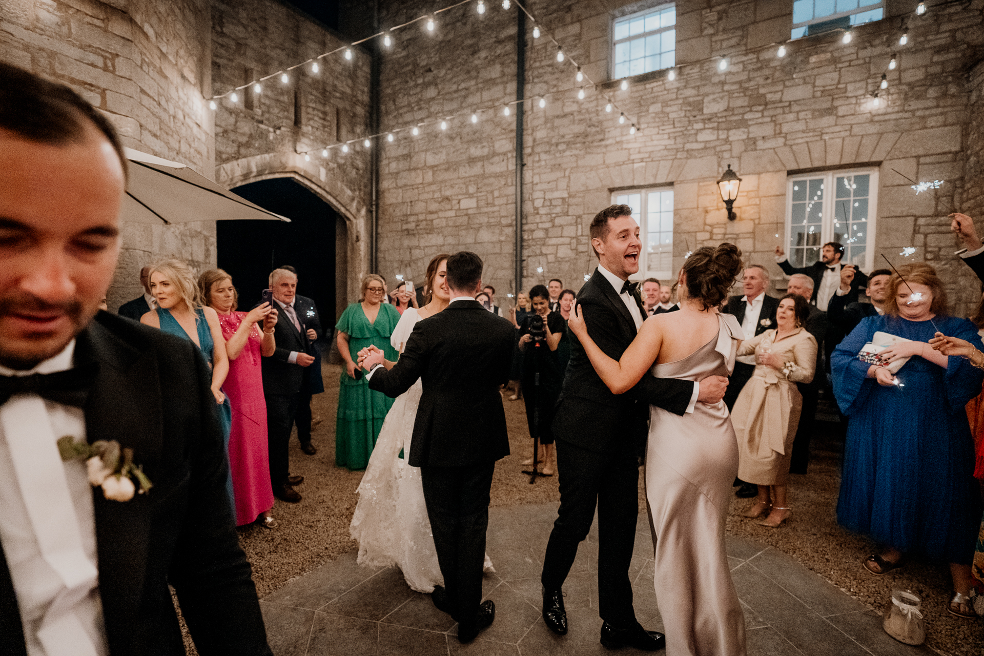 A man and woman dancing in a room full of people