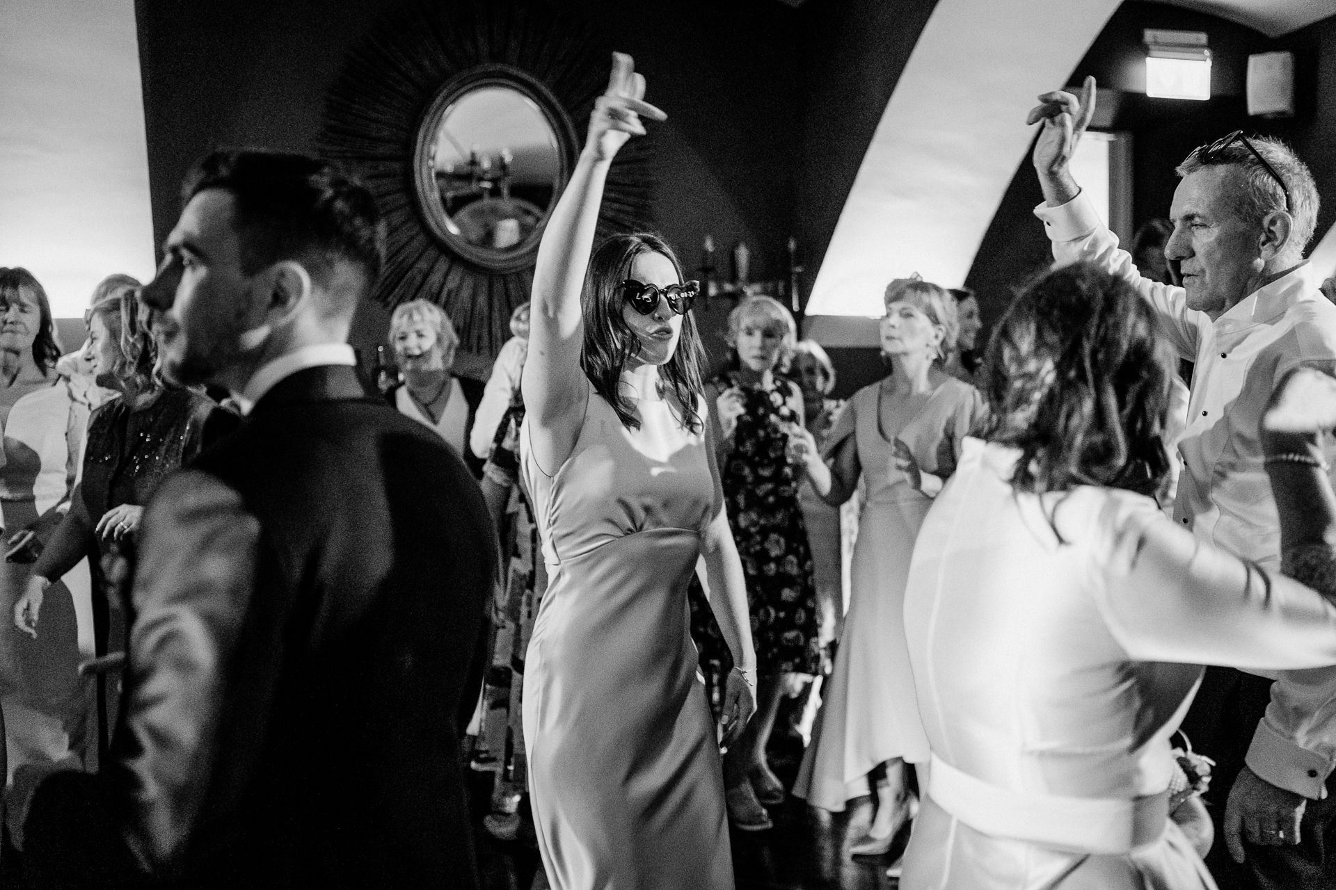 A man and woman dancing in a room with a crowd of people with Studio 54 in the background