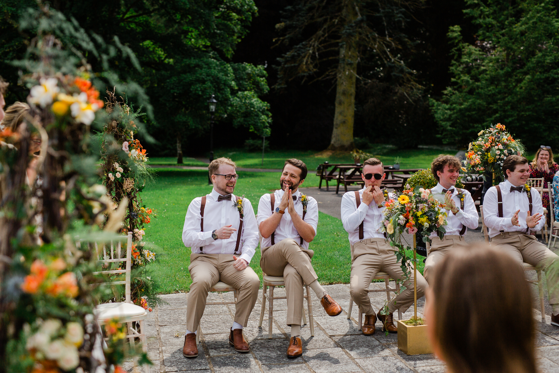 A group of people sitting on a bench with flowers