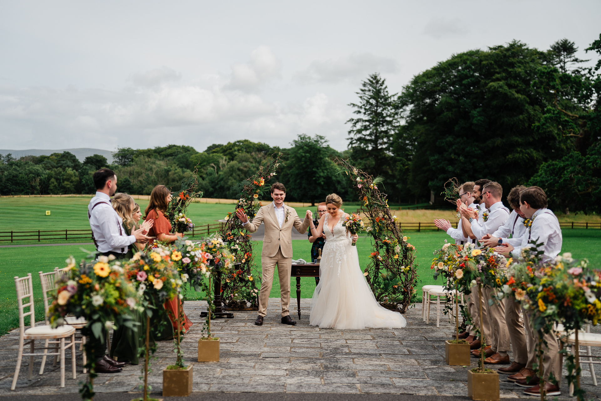 A bride and groom walking down the aisle with a group of people