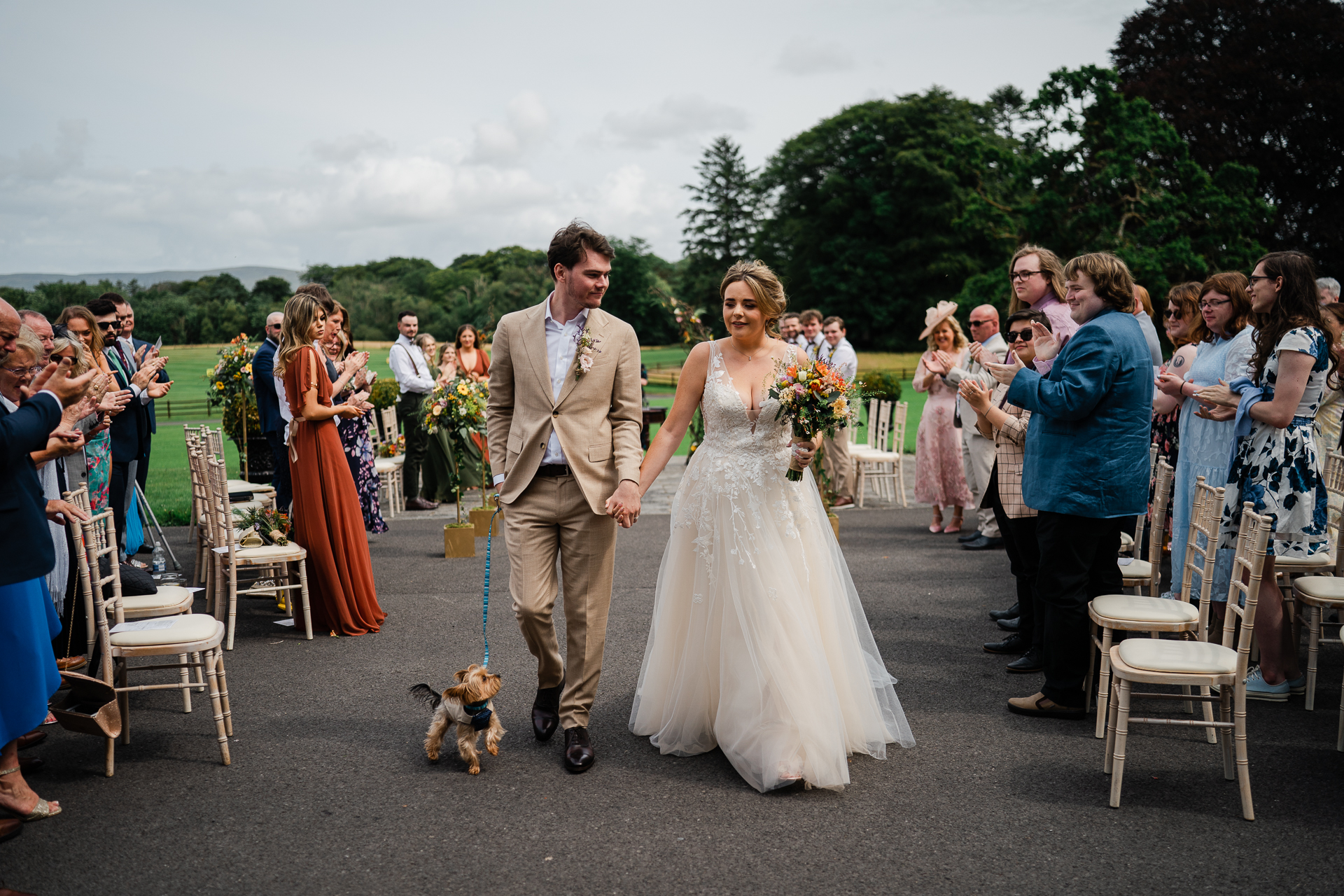 A man and woman walking down a aisle with a dog