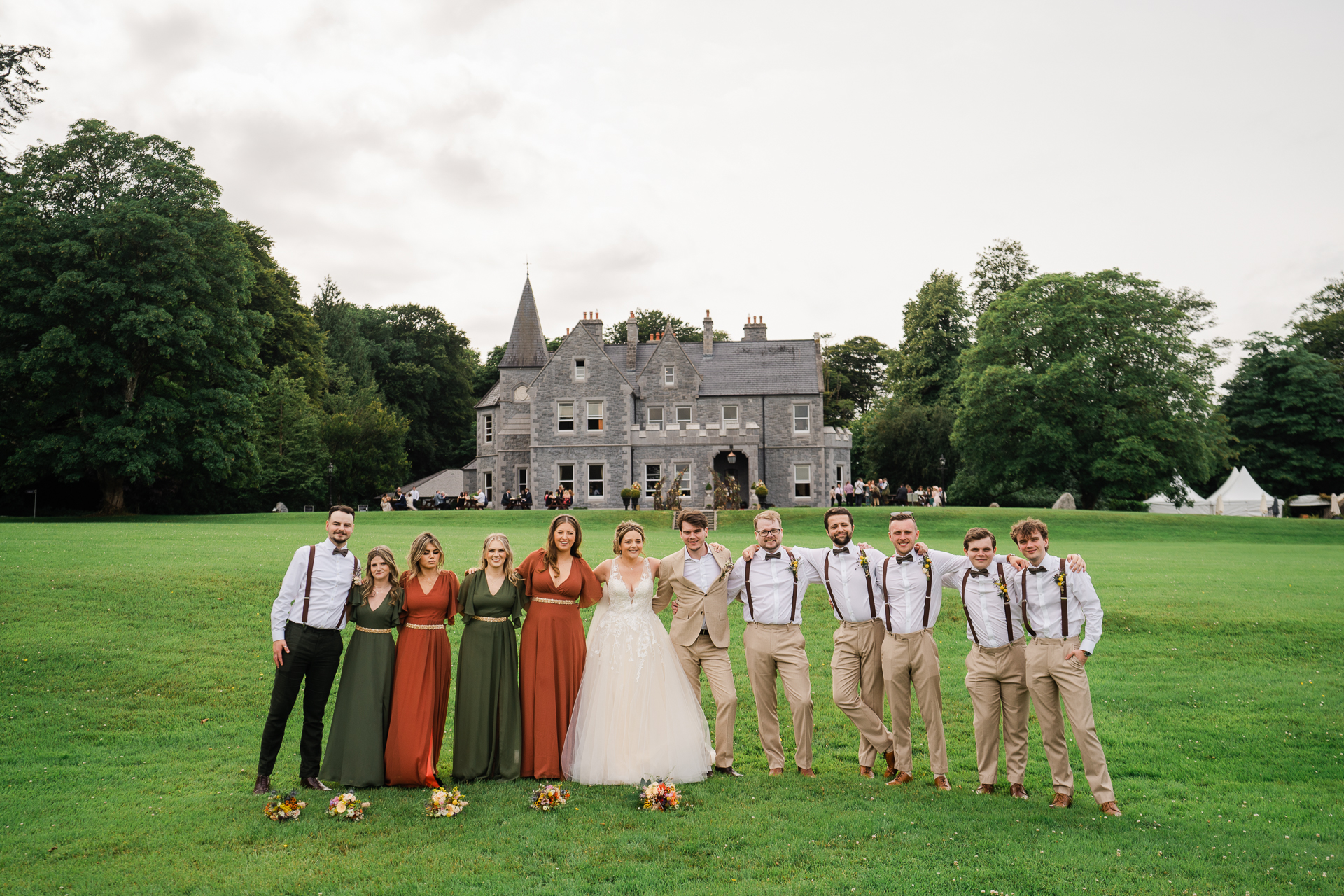 A group of people posing for a photo in front of a castle