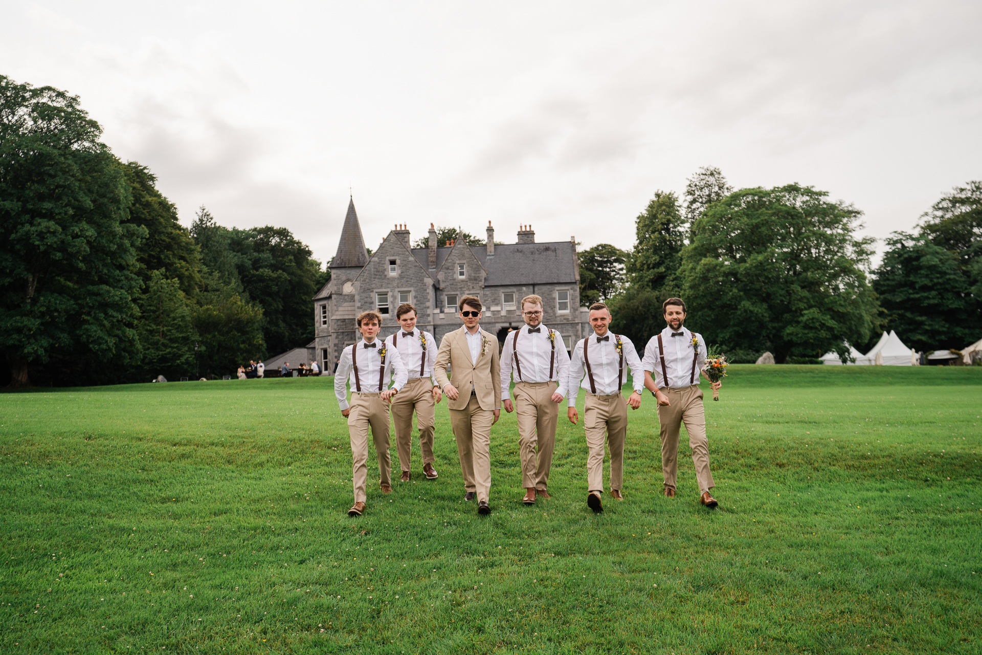 A group of men standing in a field in front of a building