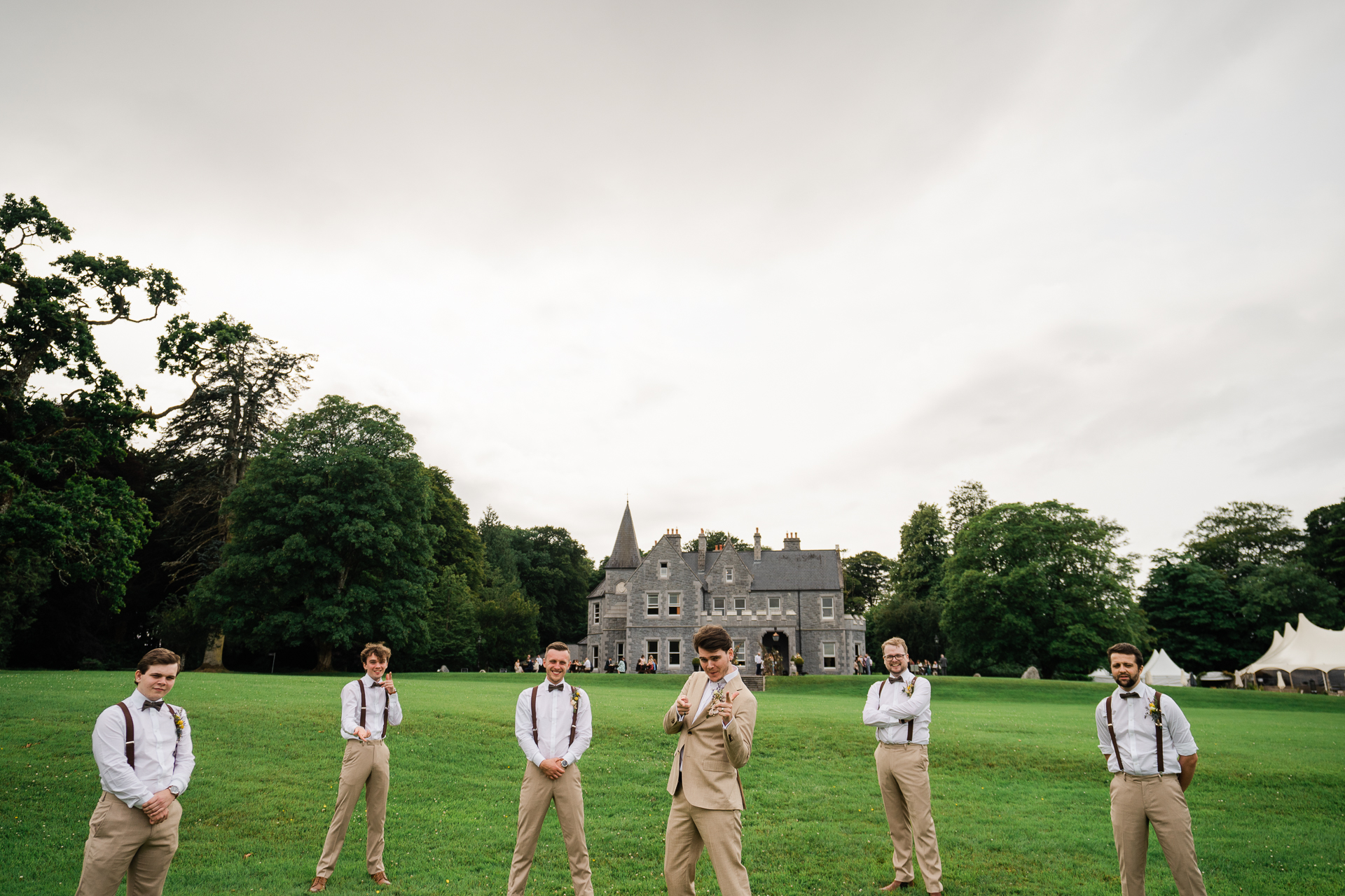 A group of people standing in a grassy field with a building in the background