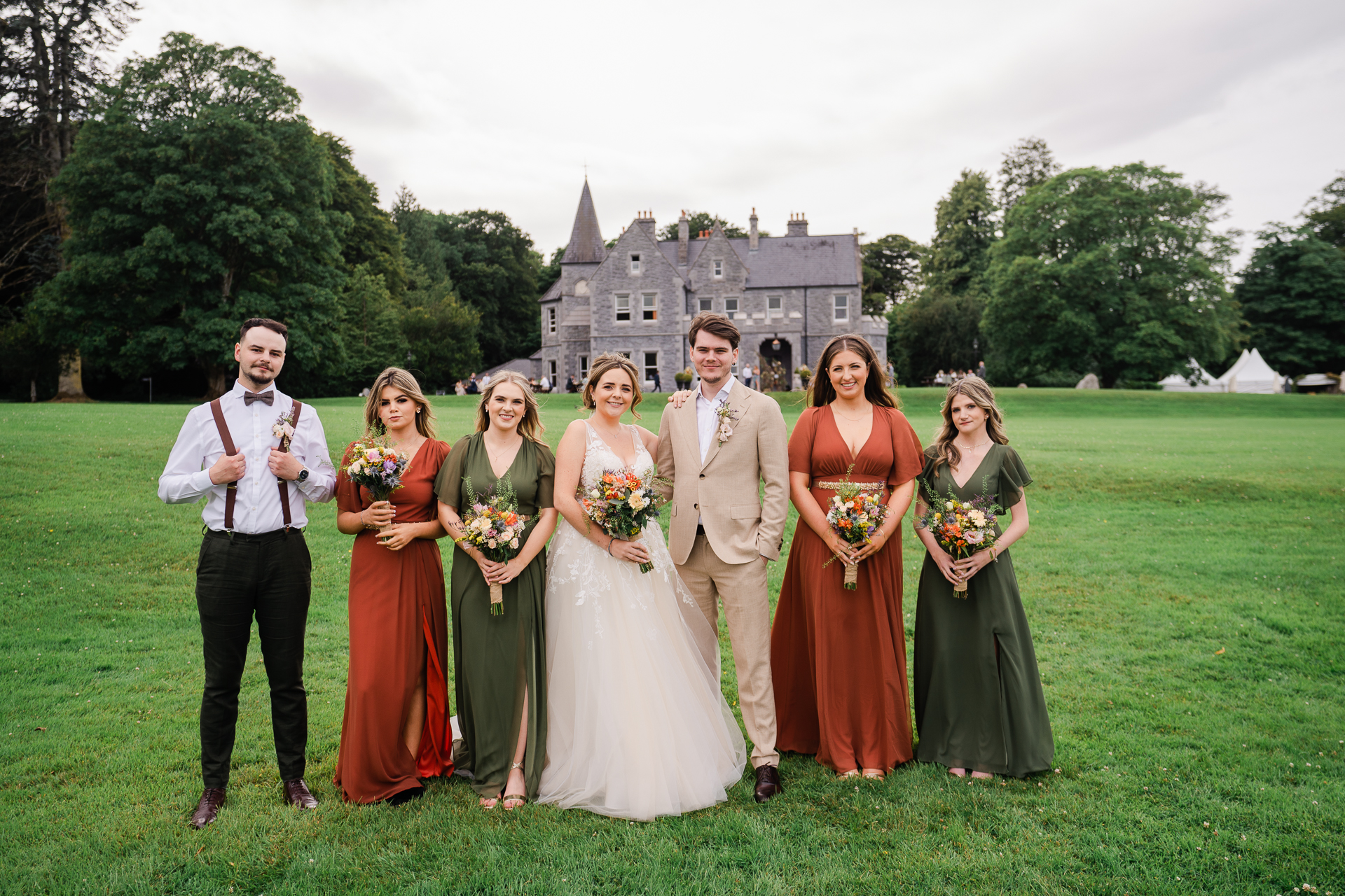 A group of people posing for a photo in front of a castle