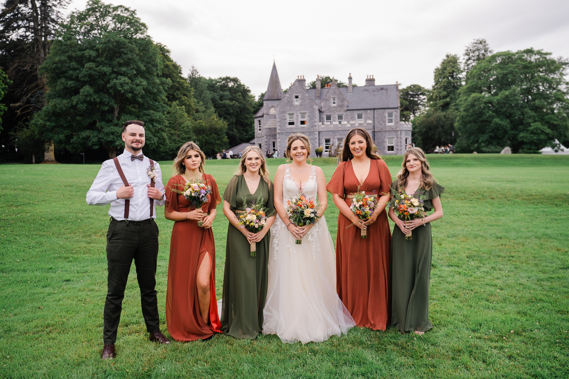 A group of people posing for a photo in front of a castle