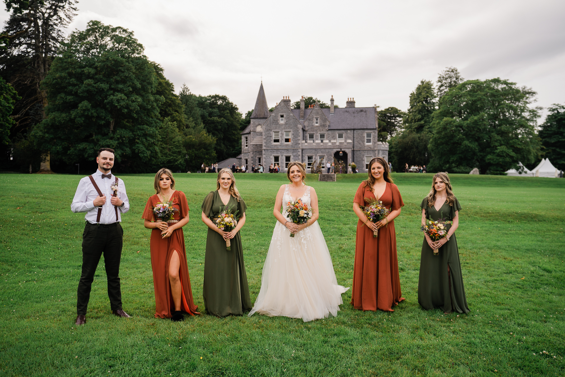 A group of people posing for a photo in front of a castle