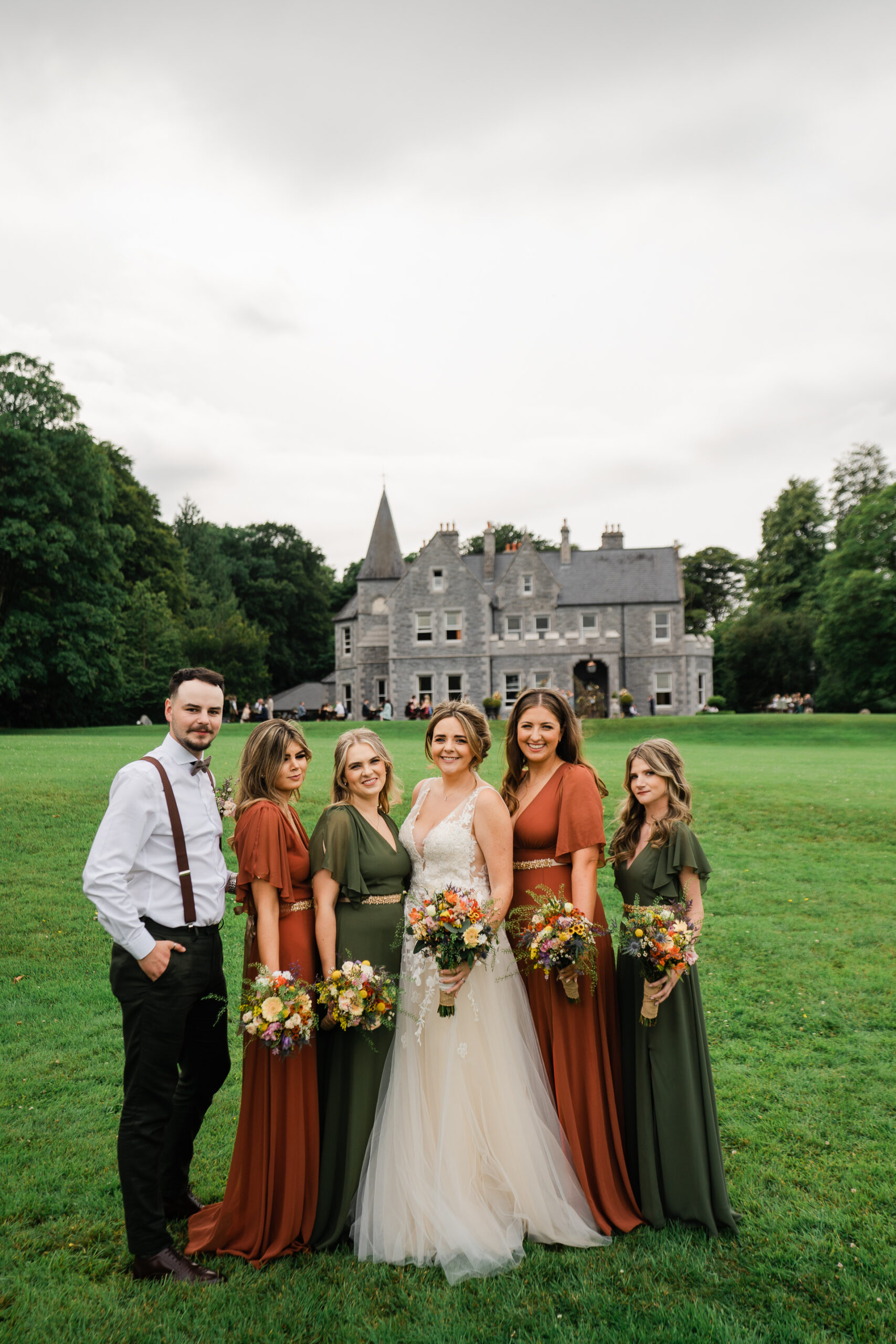 A group of people posing for a photo in front of a castle