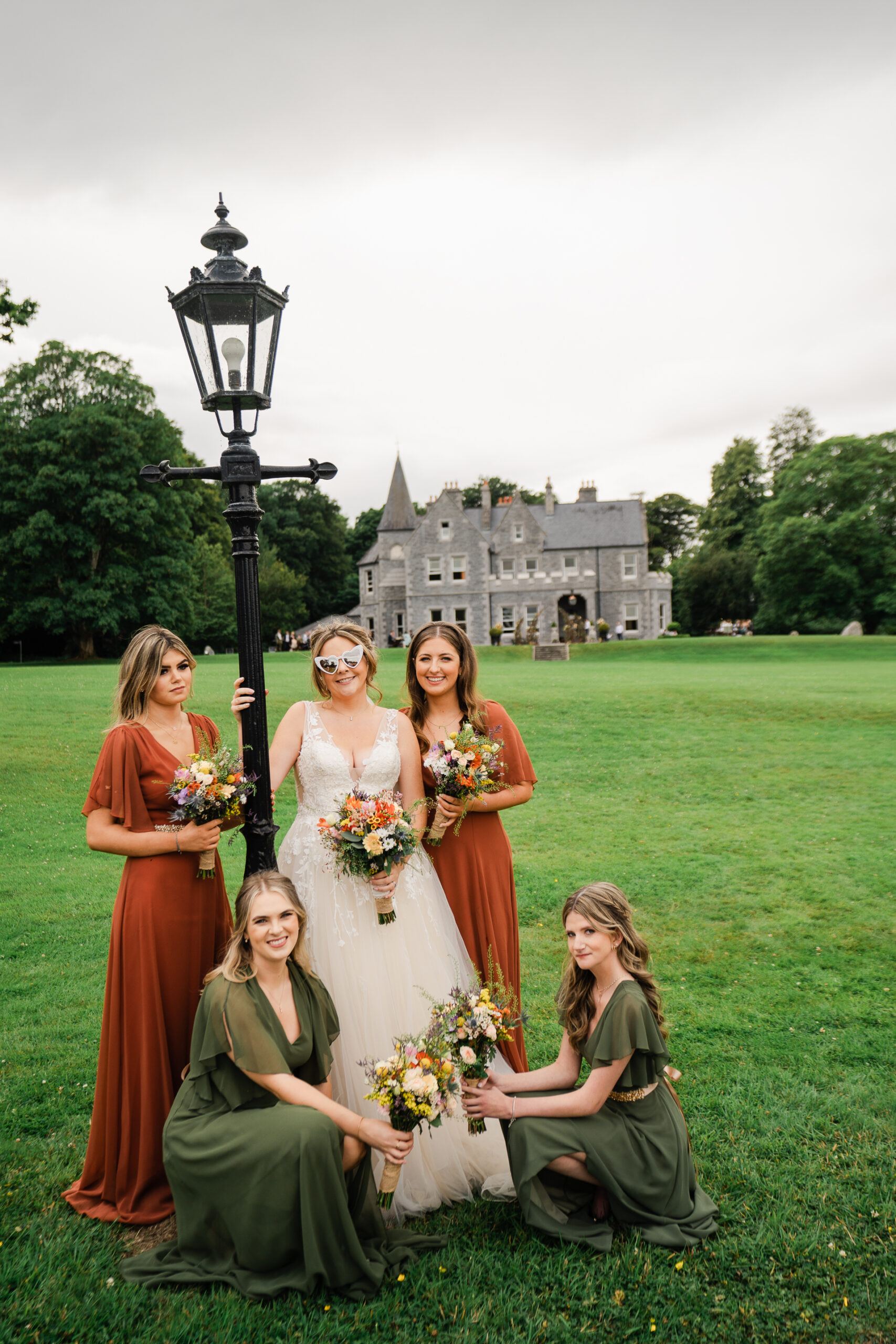 A group of women posing for a picture in front of a castle