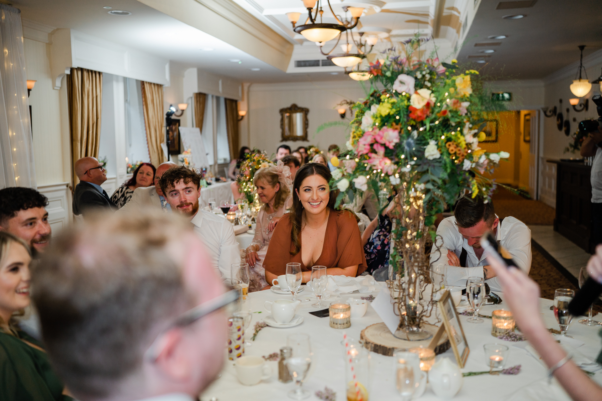 A group of people sitting at a table with flowers