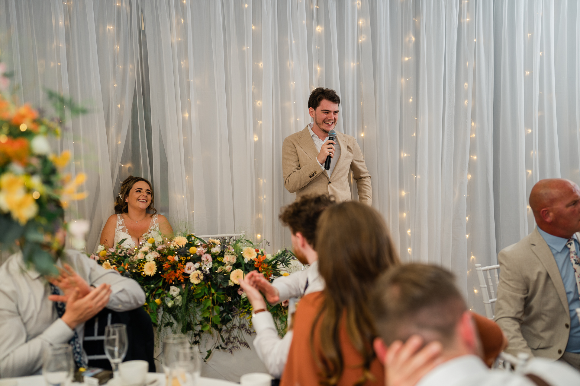 A person speaking into a microphone in front of a group of people