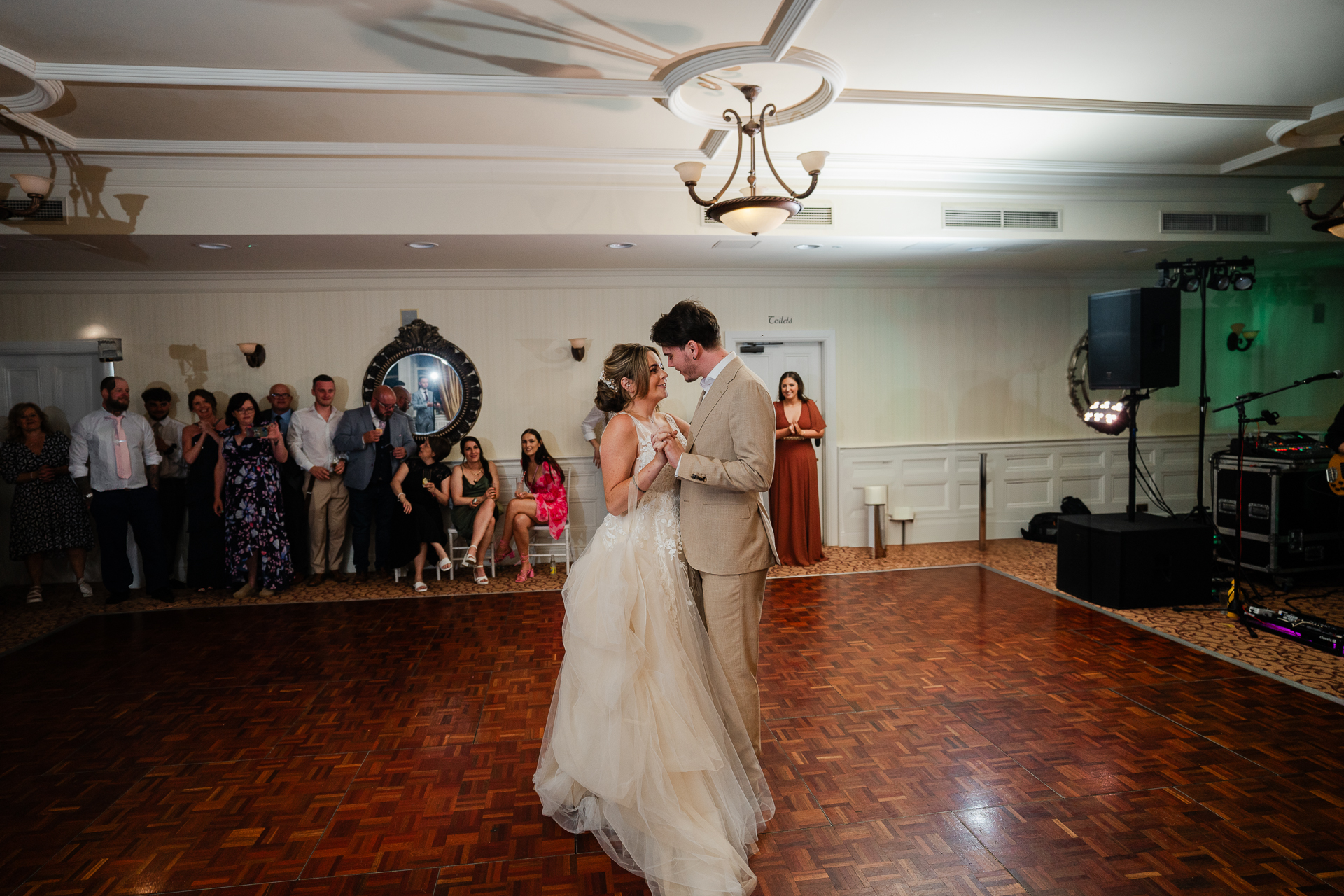 A man and woman dancing in a room with a crowd of people