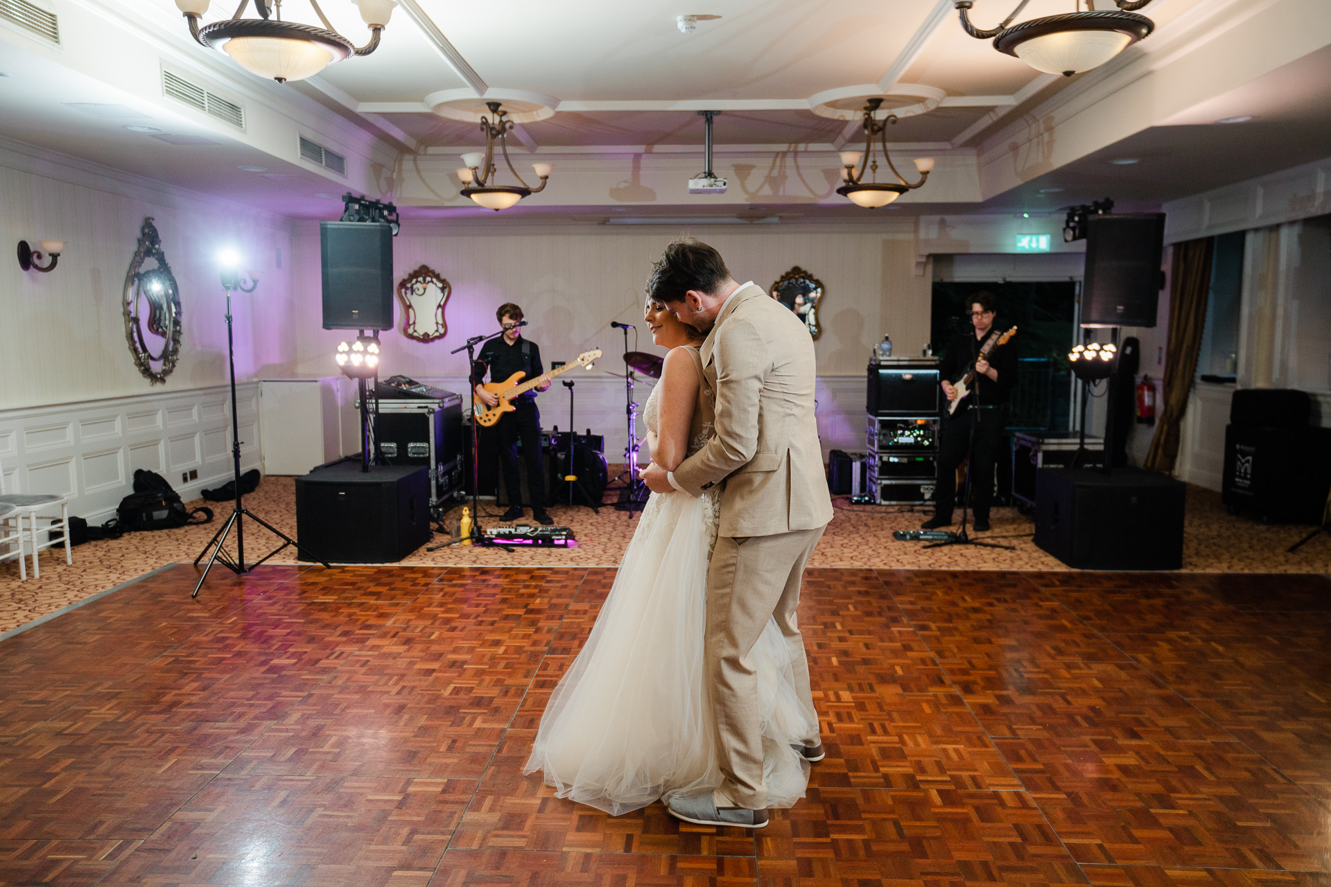 A man in a robe and a woman in a white robe on a stage with a guitar and