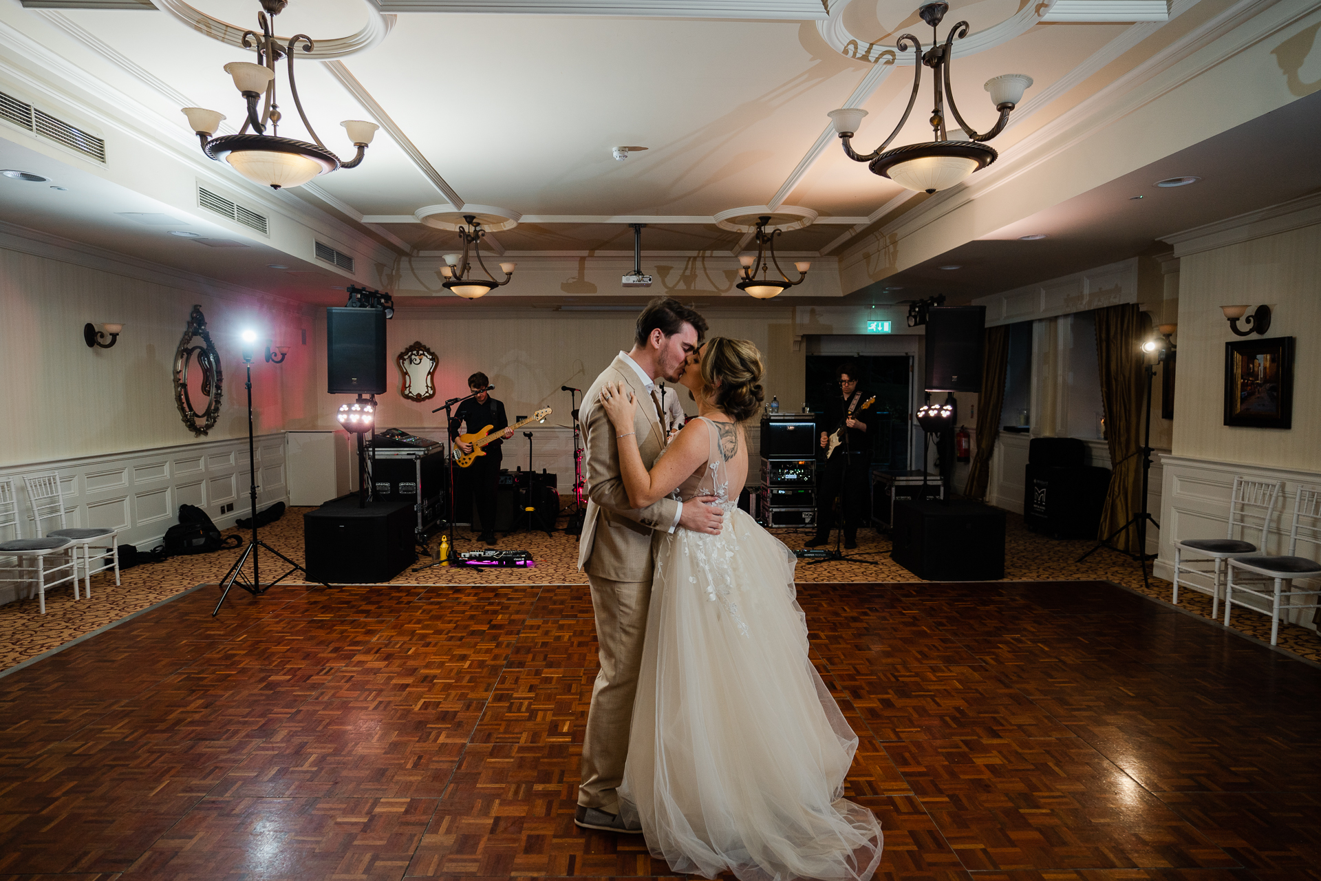 A man and woman dancing in a room with a guitar and a man playing a guitar