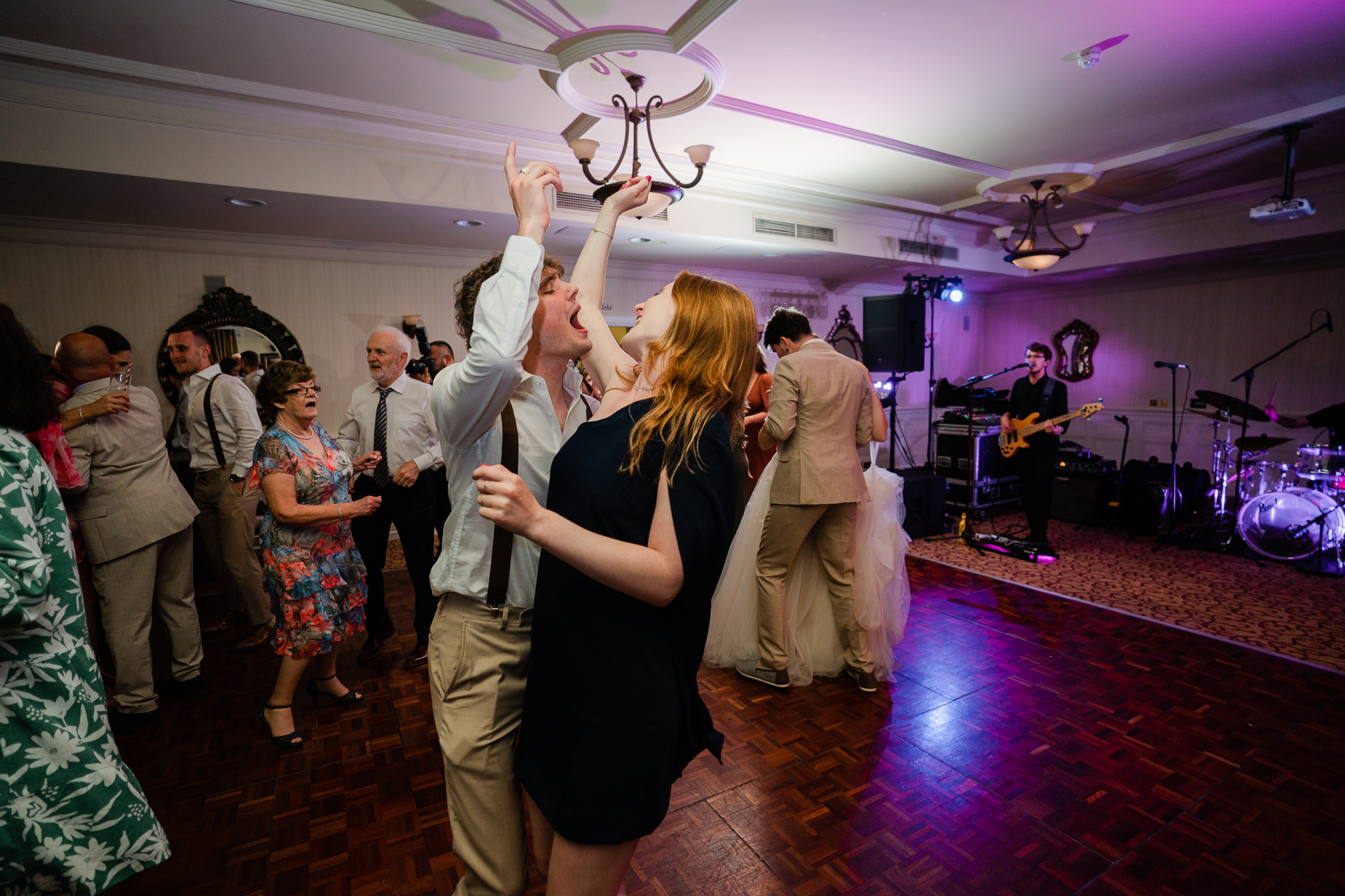 A man and woman dancing in a room with a crowd of people