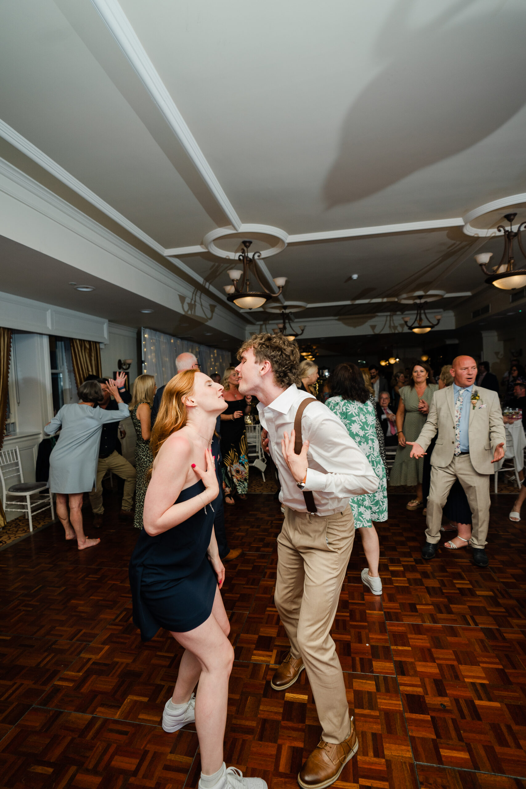 A man and woman dancing in a room full of people