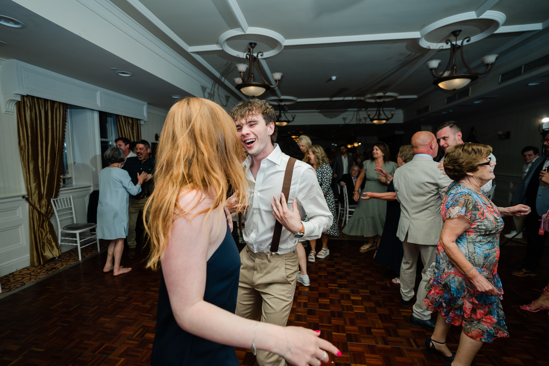 A man and woman dancing in a room with other people