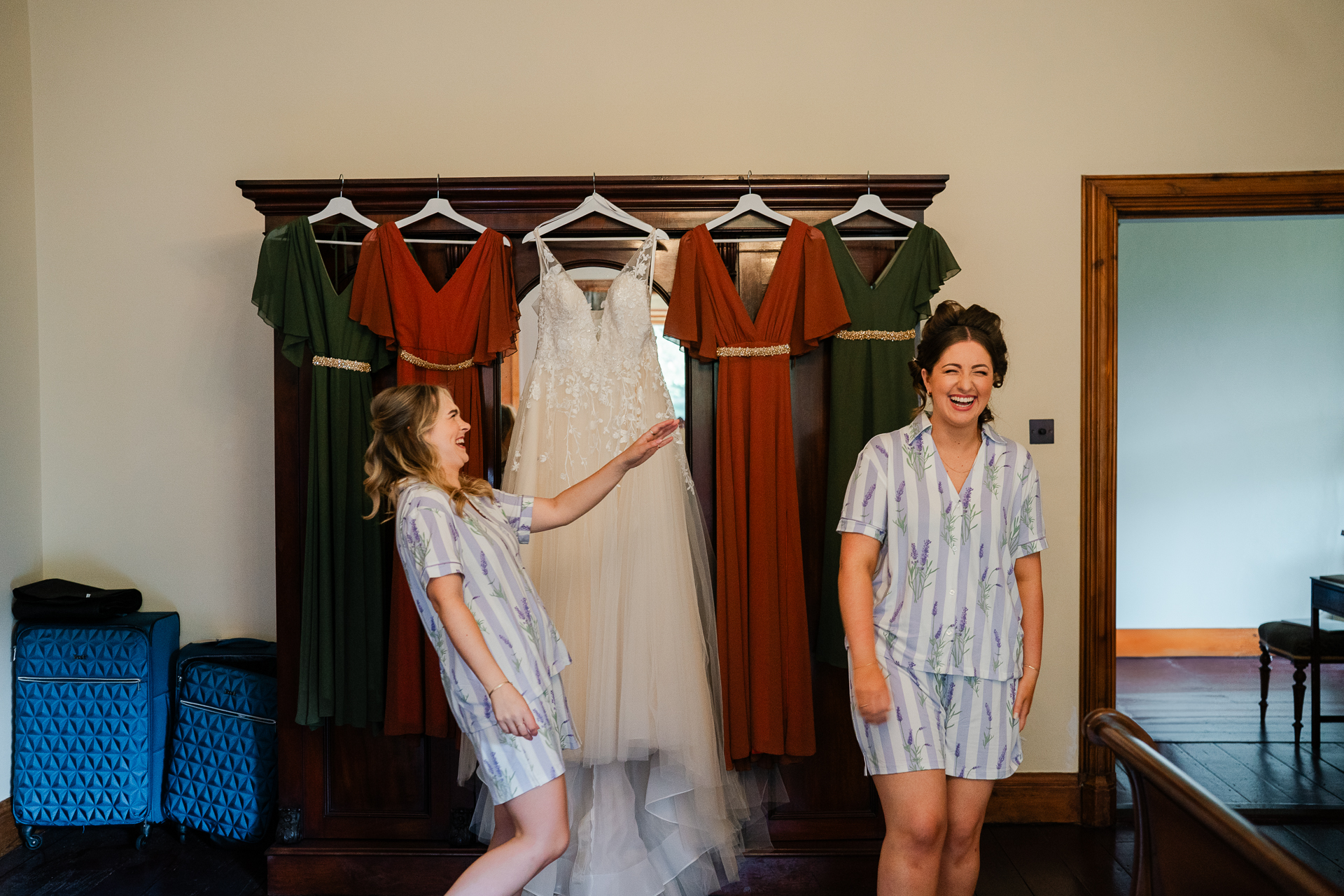 A person and a girl in a room with clothes on a rack