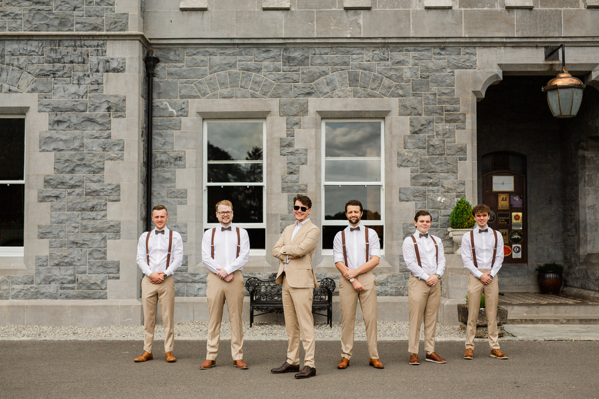 A group of men in white shirts standing in front of a building