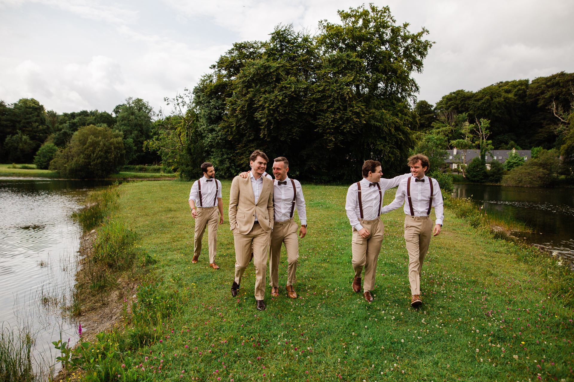 A group of men walking on a path by a river