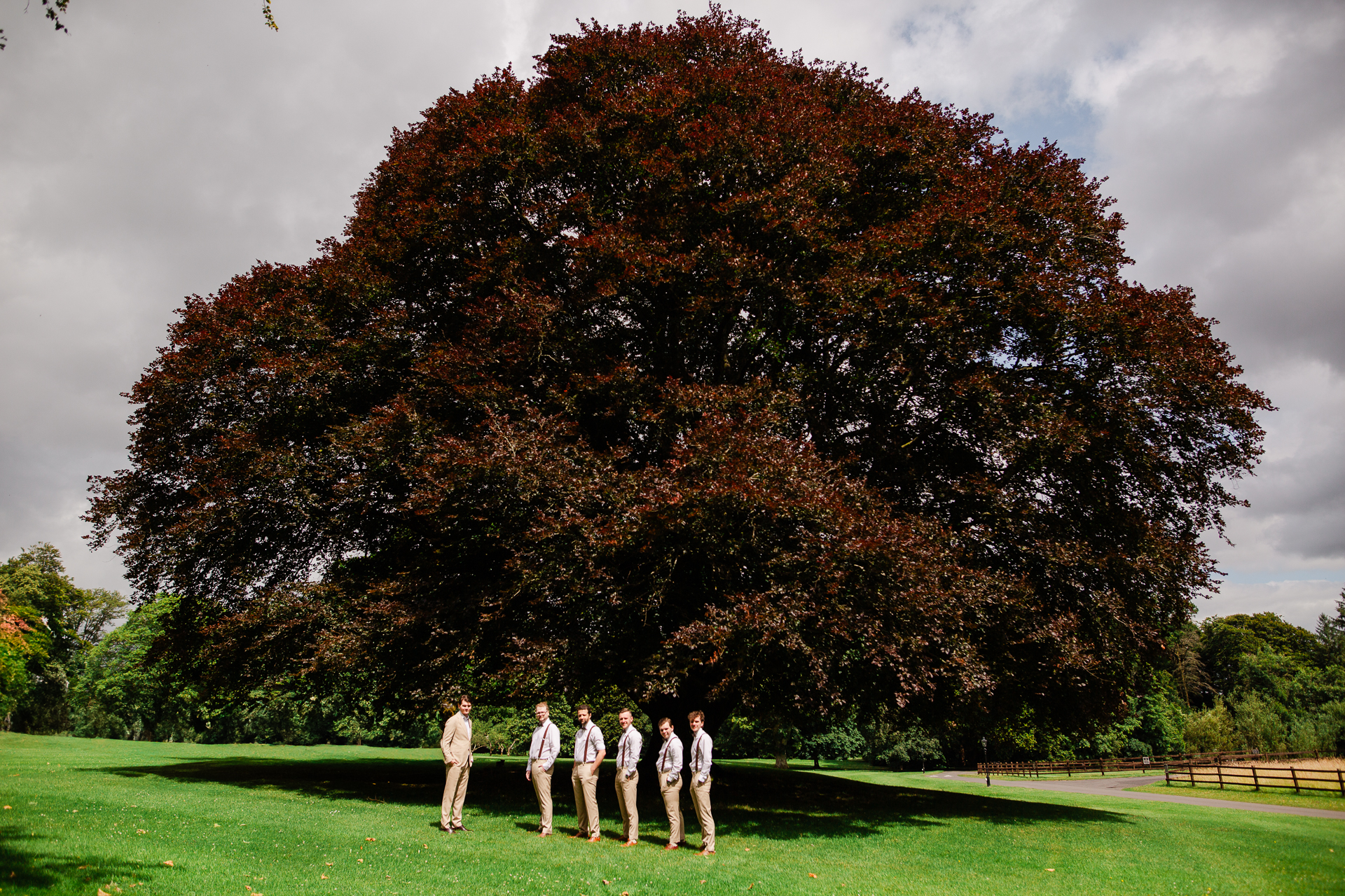 A group of people standing in front of a tree