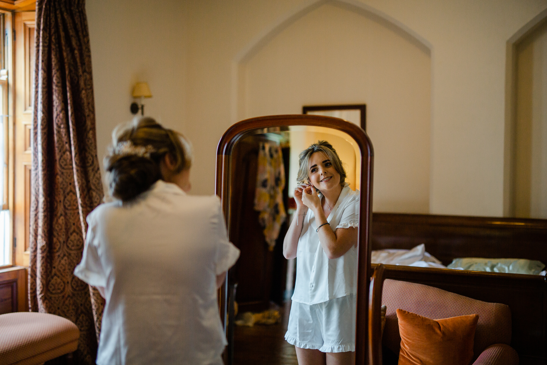 A person taking a picture of a girl in a mirror