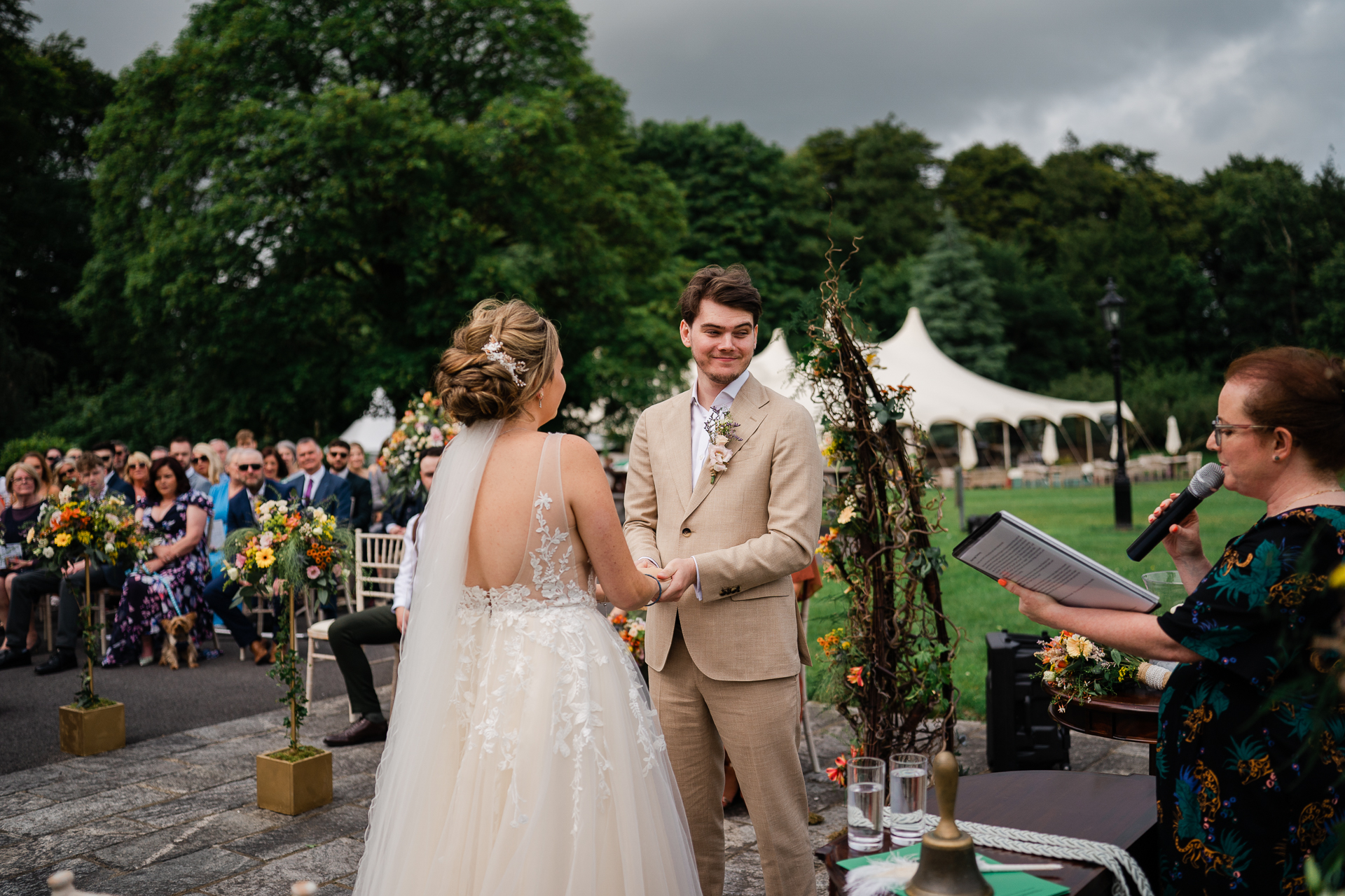 A man and woman walking down a aisle with a microphone and people in the background