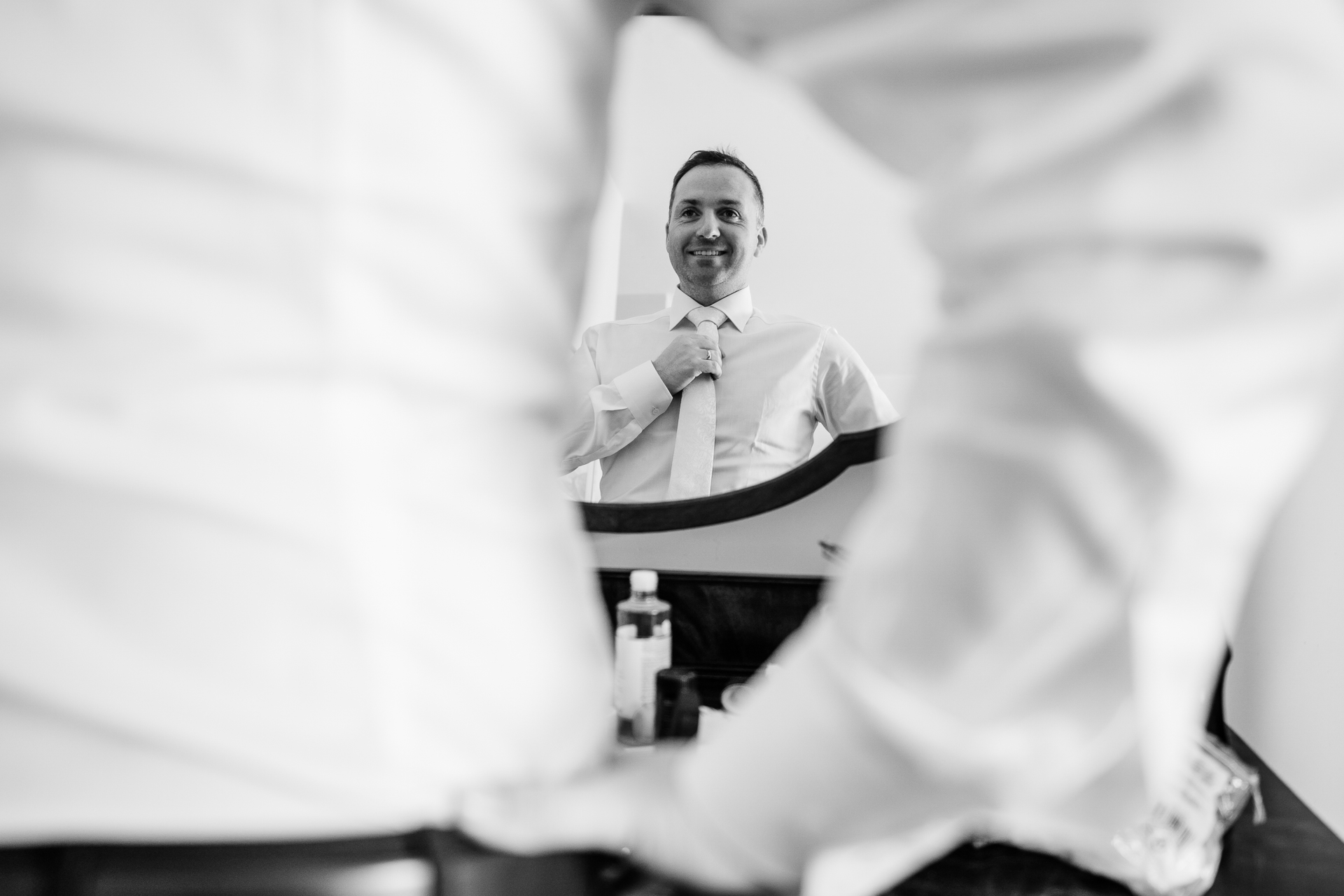 A man in a tie sits in a chair