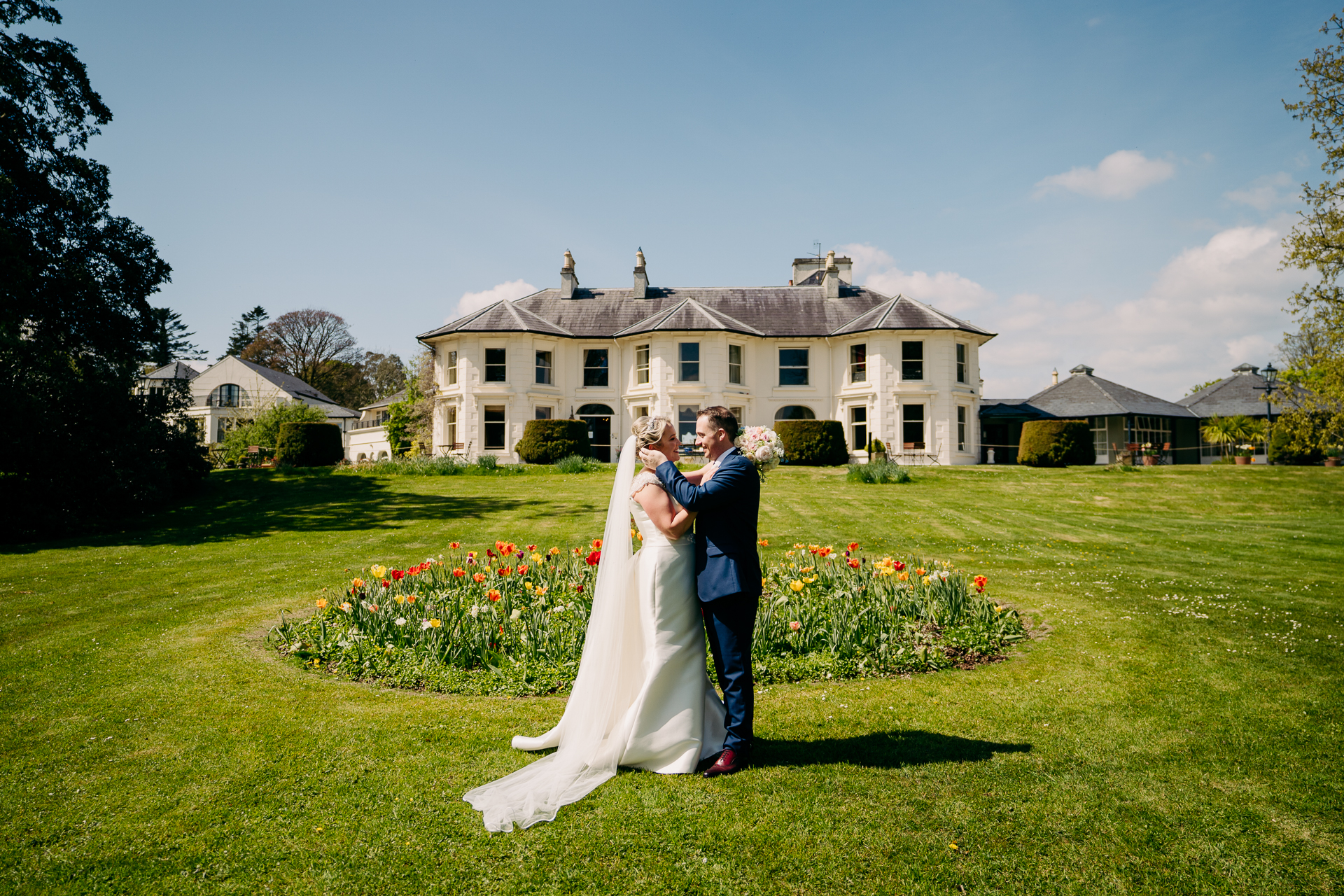 A man and woman kissing in front of a house