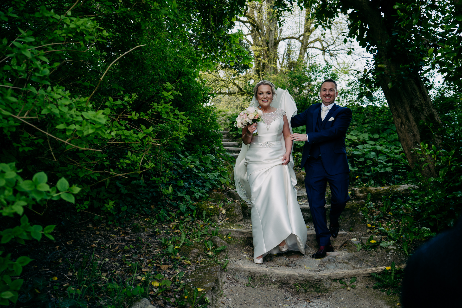 A man and woman walking down a path in a forest