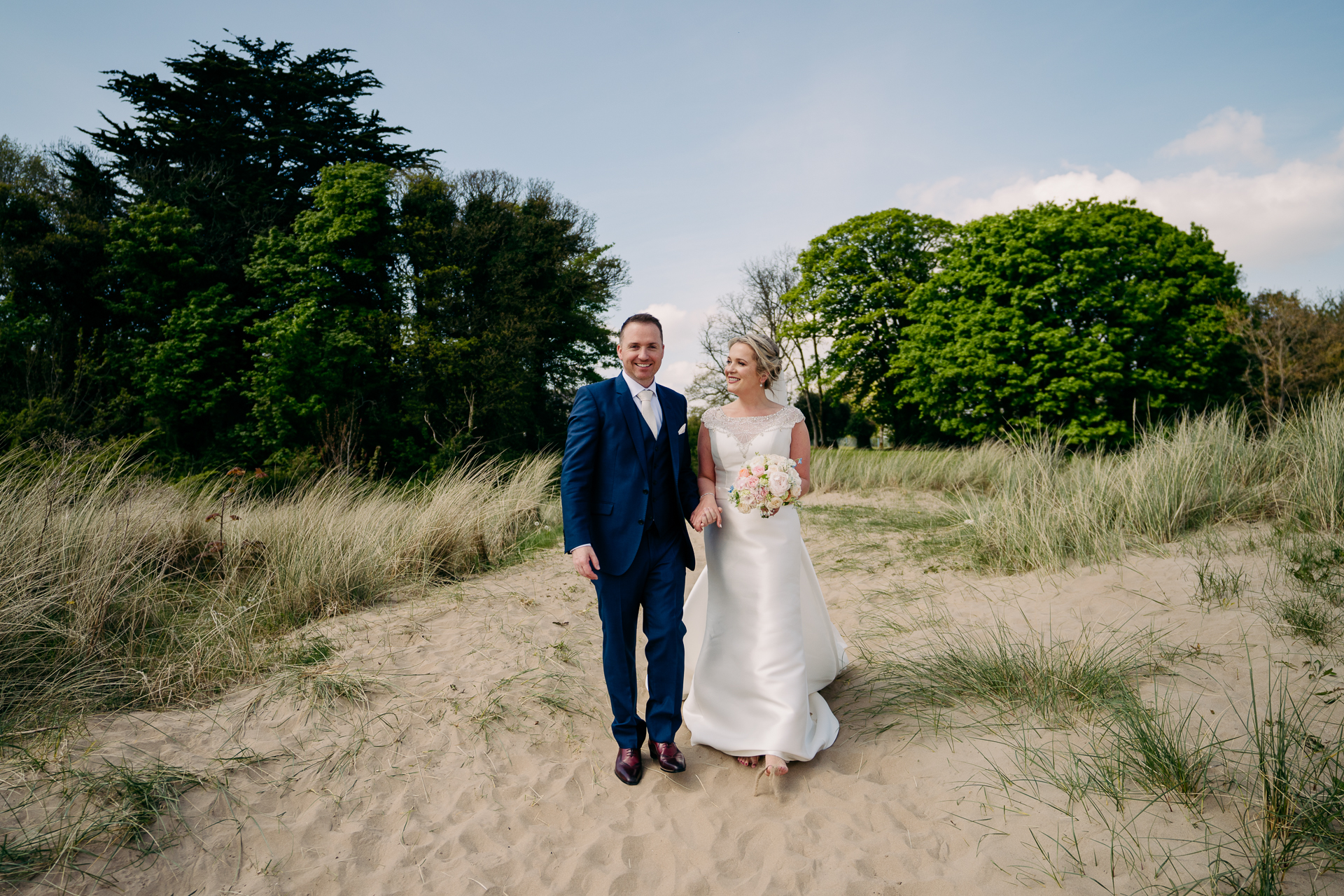 A man and woman posing for a picture on a dirt road