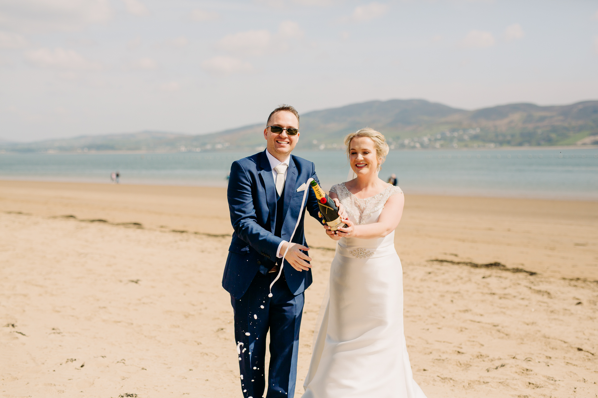 A man and woman posing for a picture on a beach