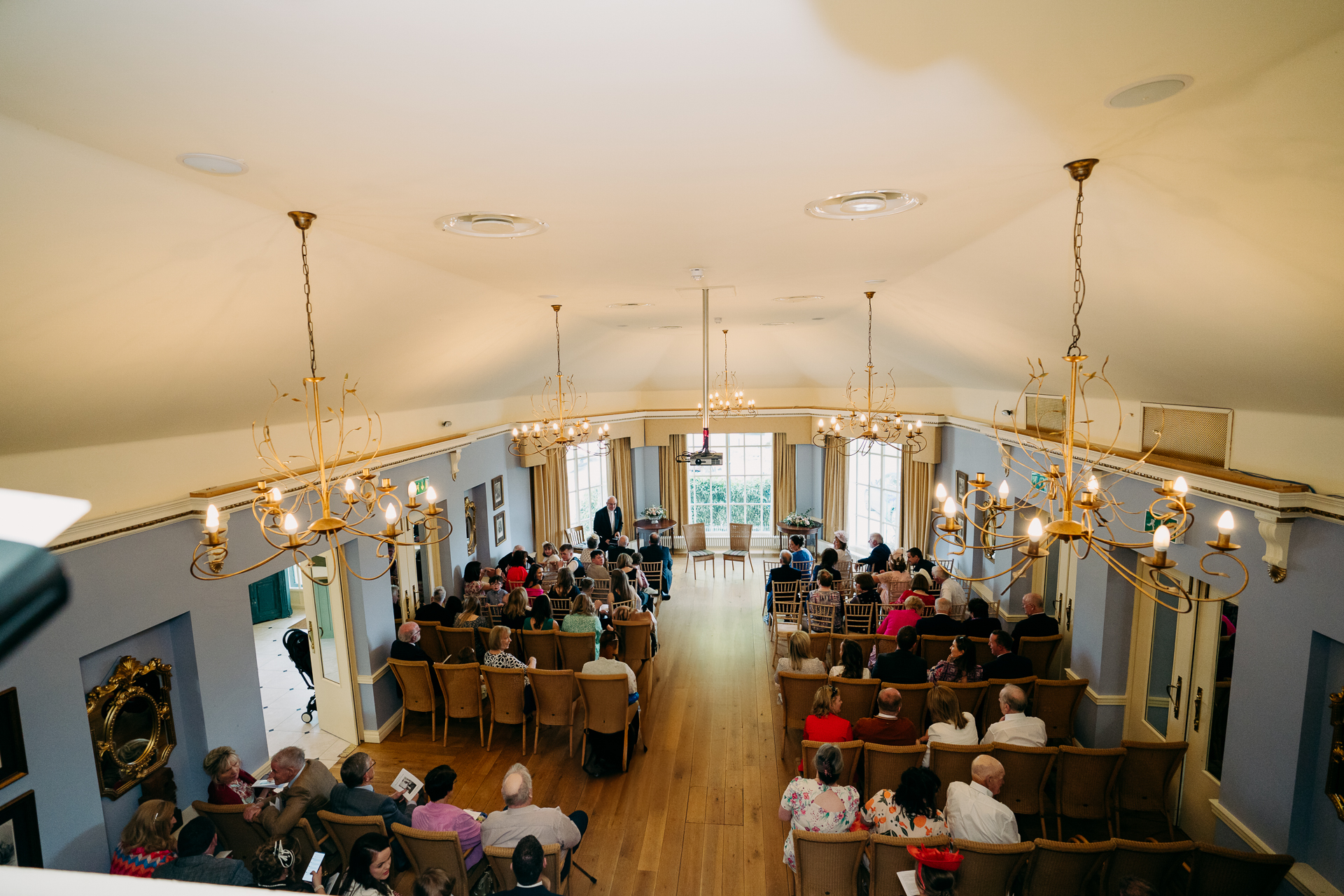 A group of people sitting in a room with chandeliers