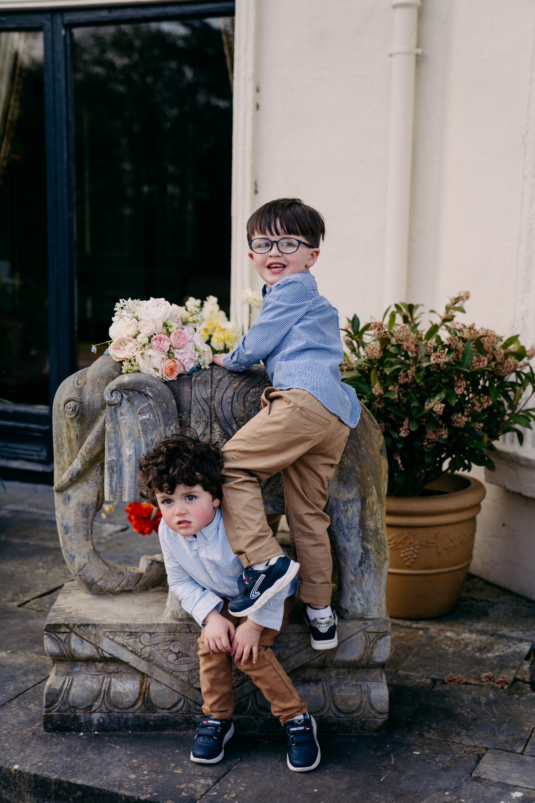 A boy and a girl sitting on a stone bench