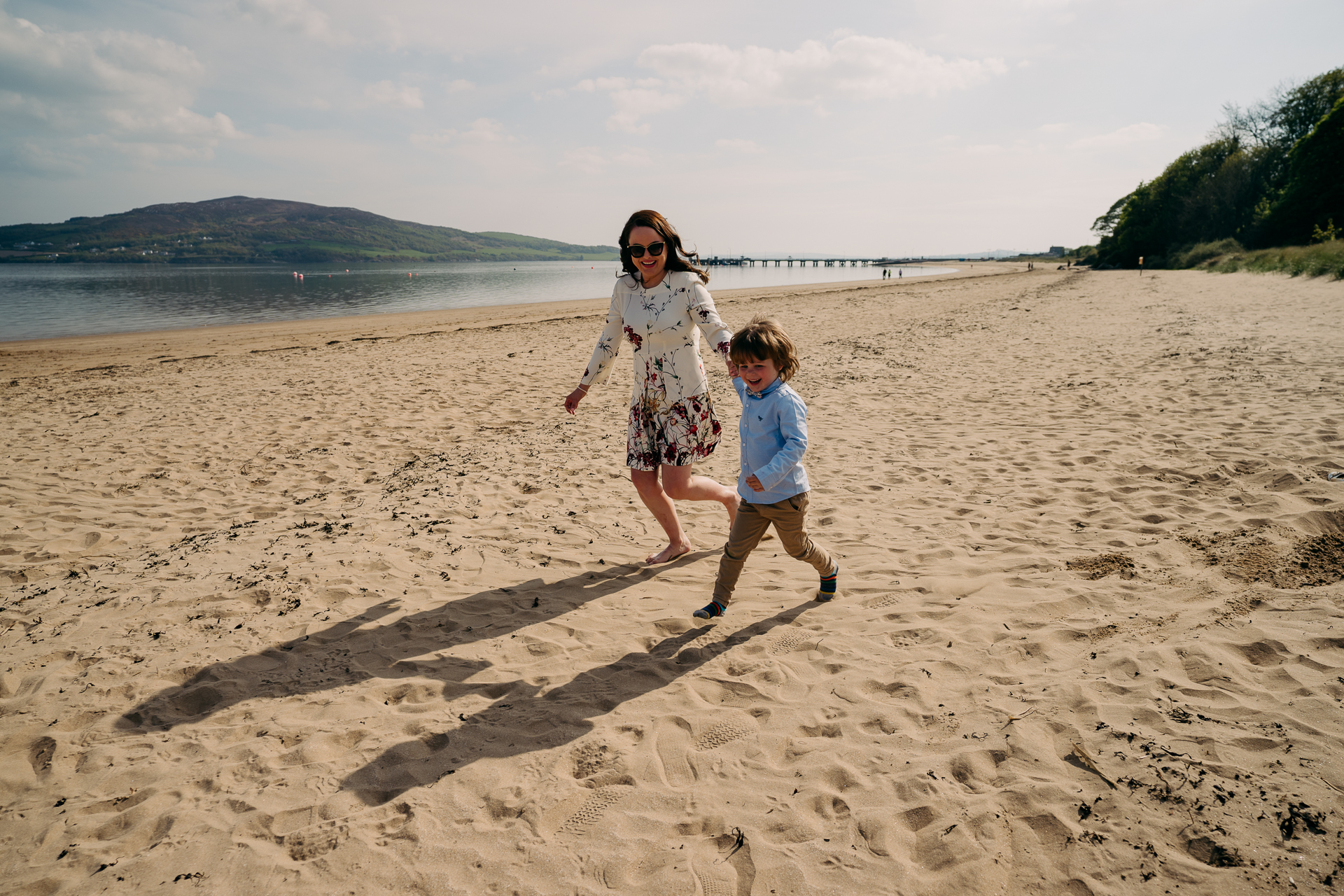 A person and a child running on a beach