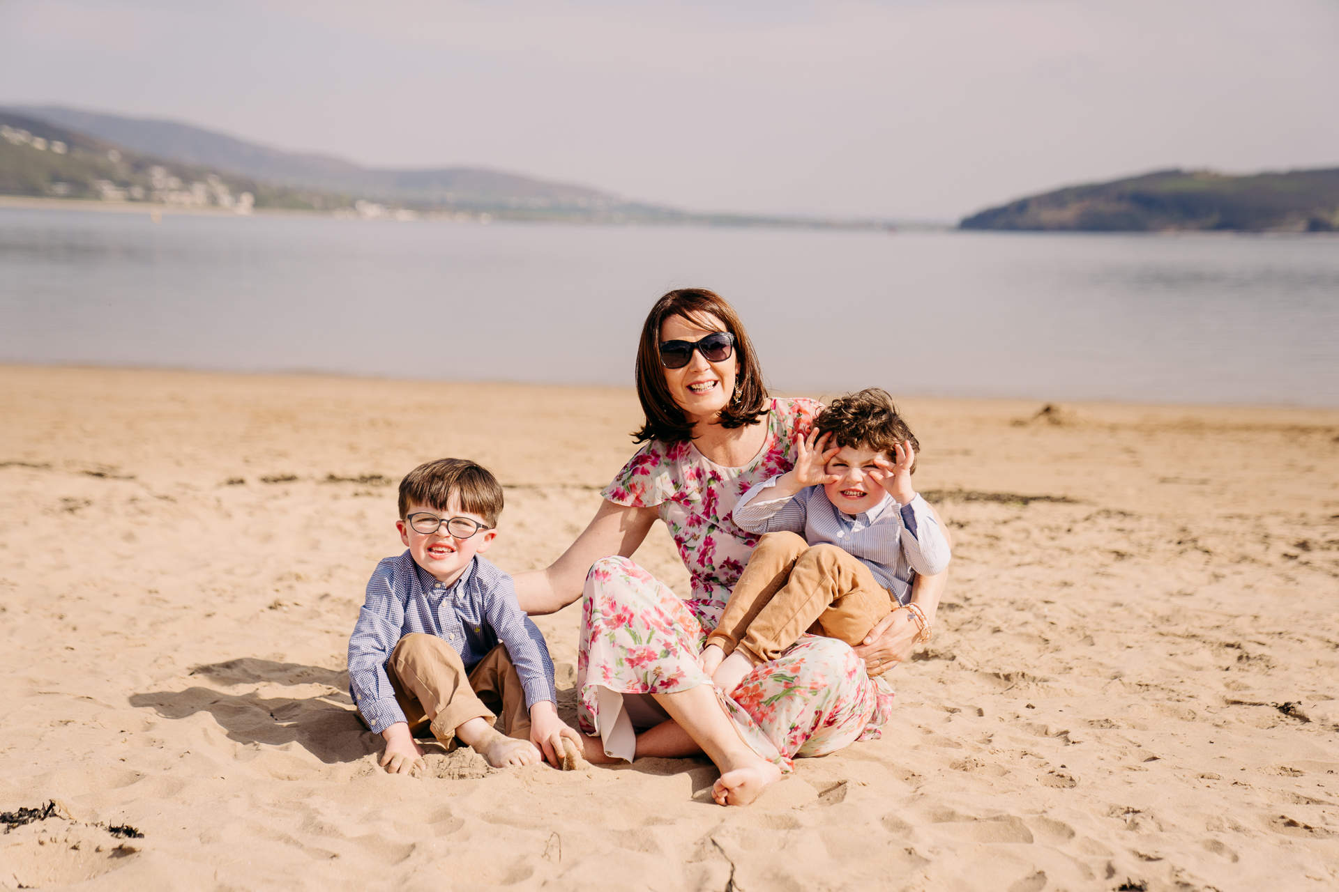 A person and two children sitting on a beach