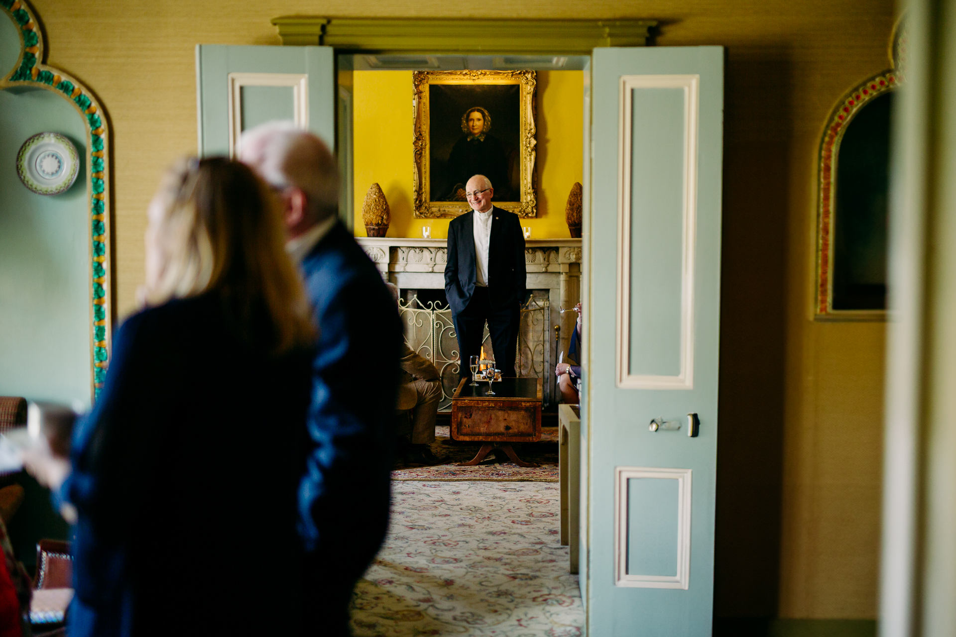 A person in a suit standing in front of a mirror